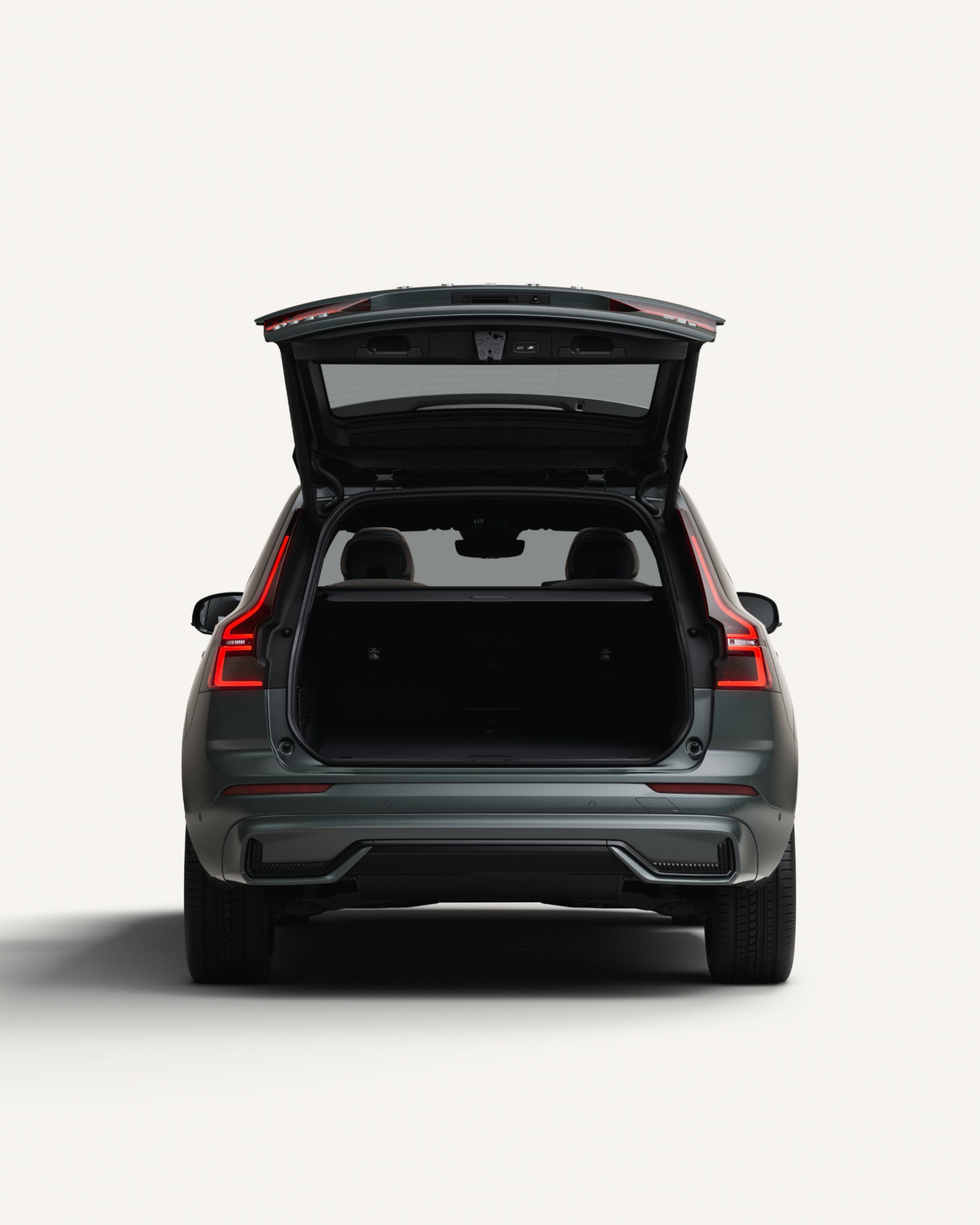 Il vano di carico posteriore aperto del SUV di medie dimensioni Volvo XC60 Plug-in Hybrid in uno studio bianco.