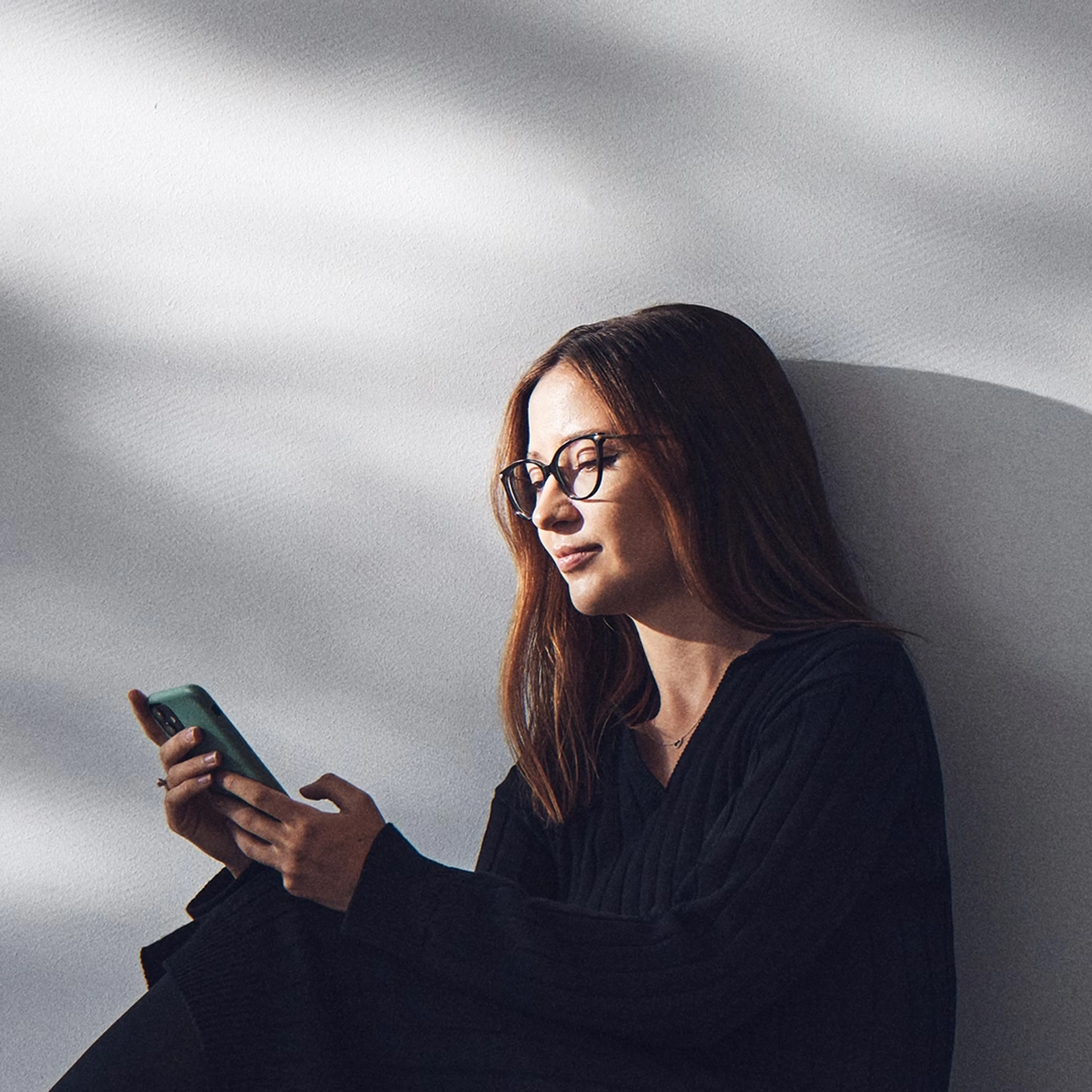 Una mujer utiliza su teléfono móvil para acceder a Volvo Cars app.