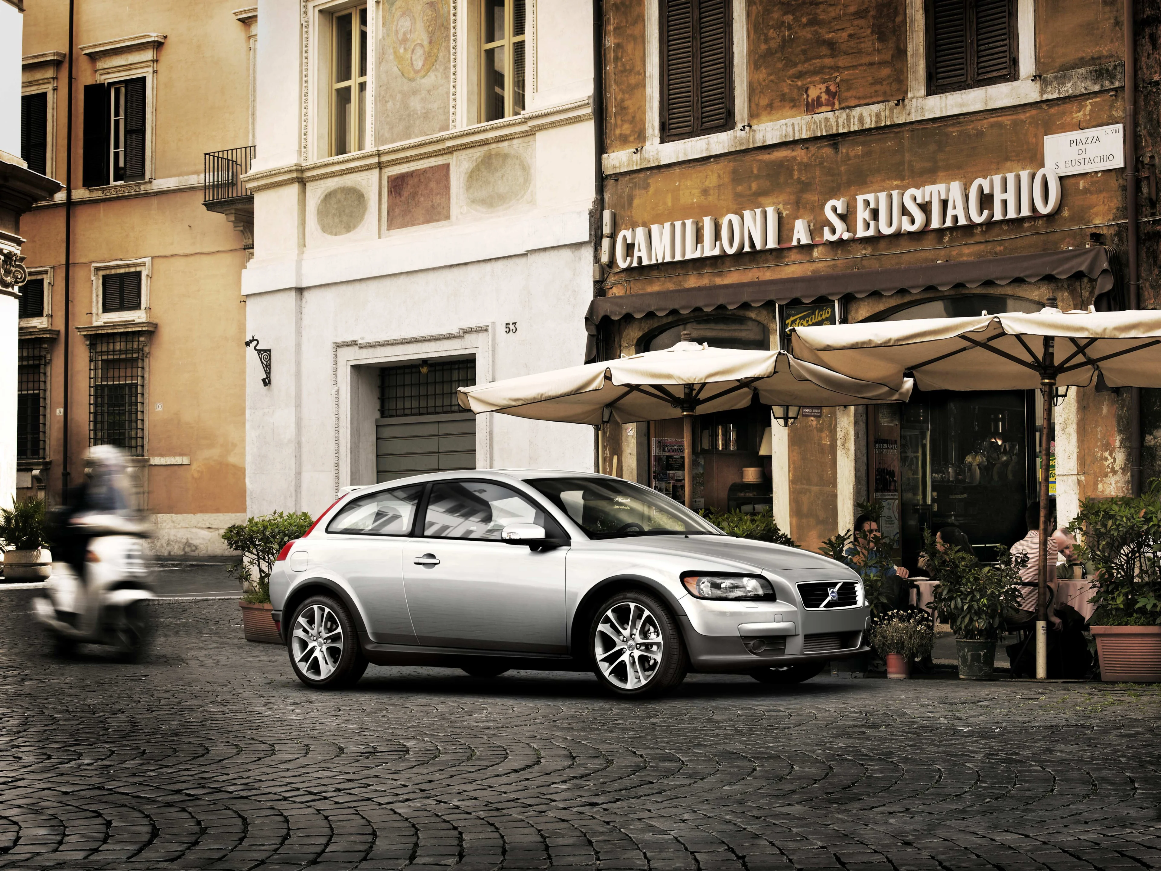 Volvo C30 garée devant un vieux bâtiment.