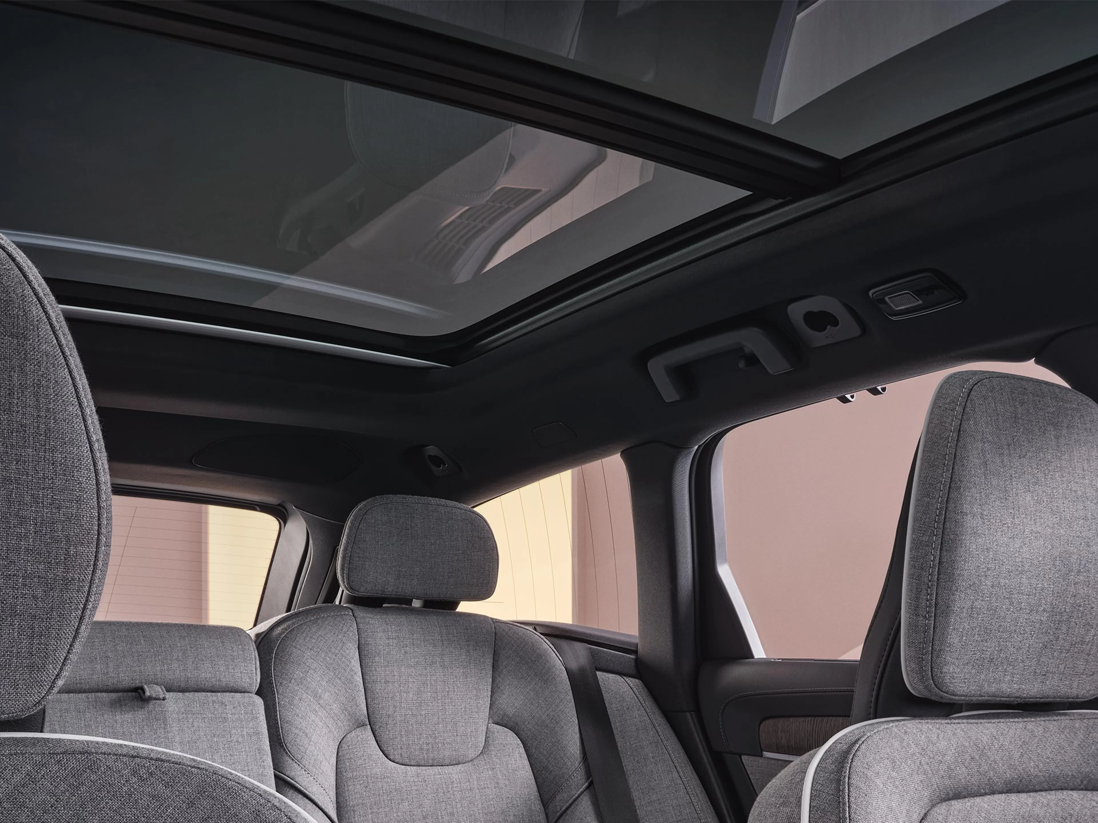 Pohled z interiéru plug-in hybridního vozu Volvo V90 na panoramatickou střechu.