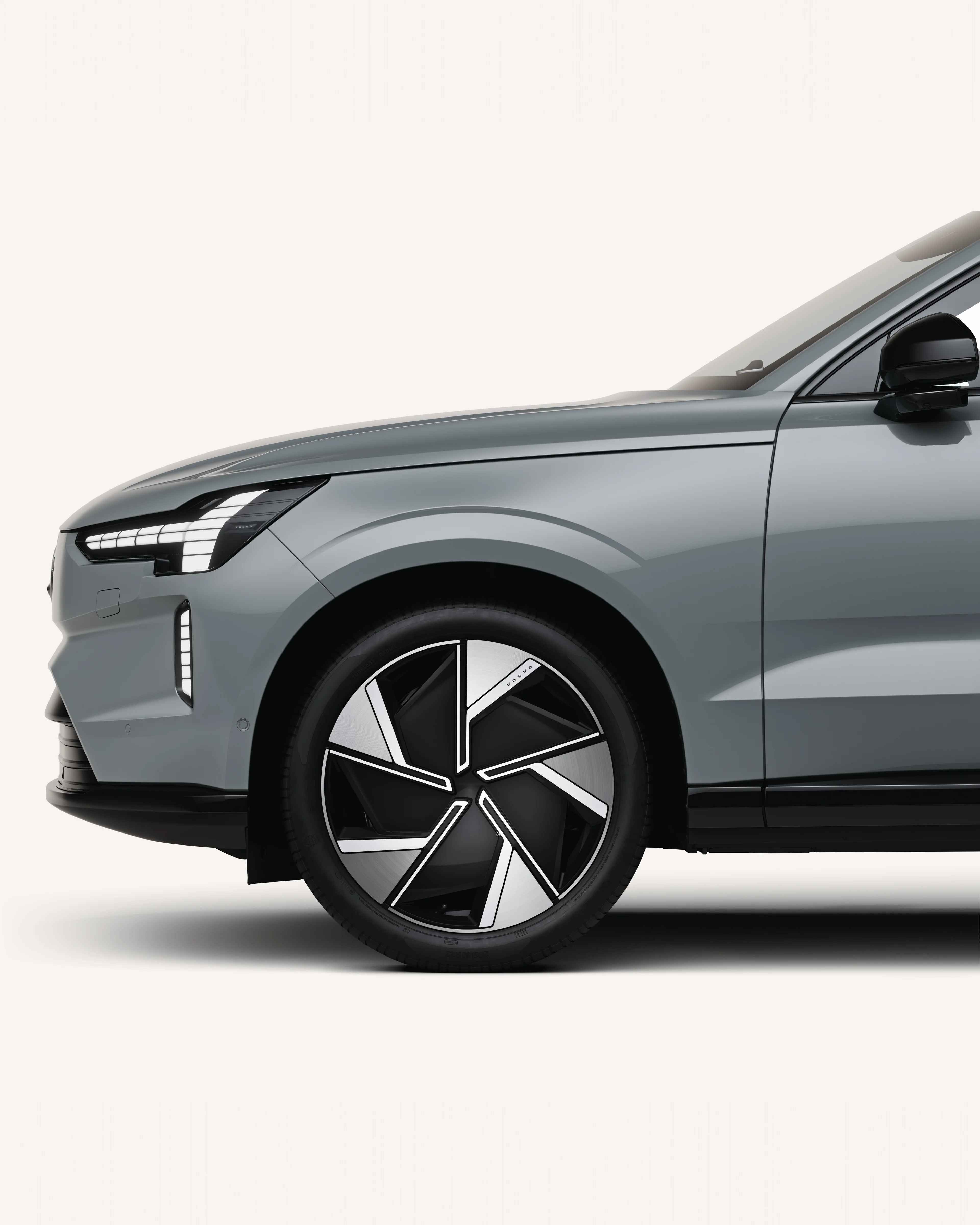 Främre halvan av Volvo EX90 i vit studiomiljö.