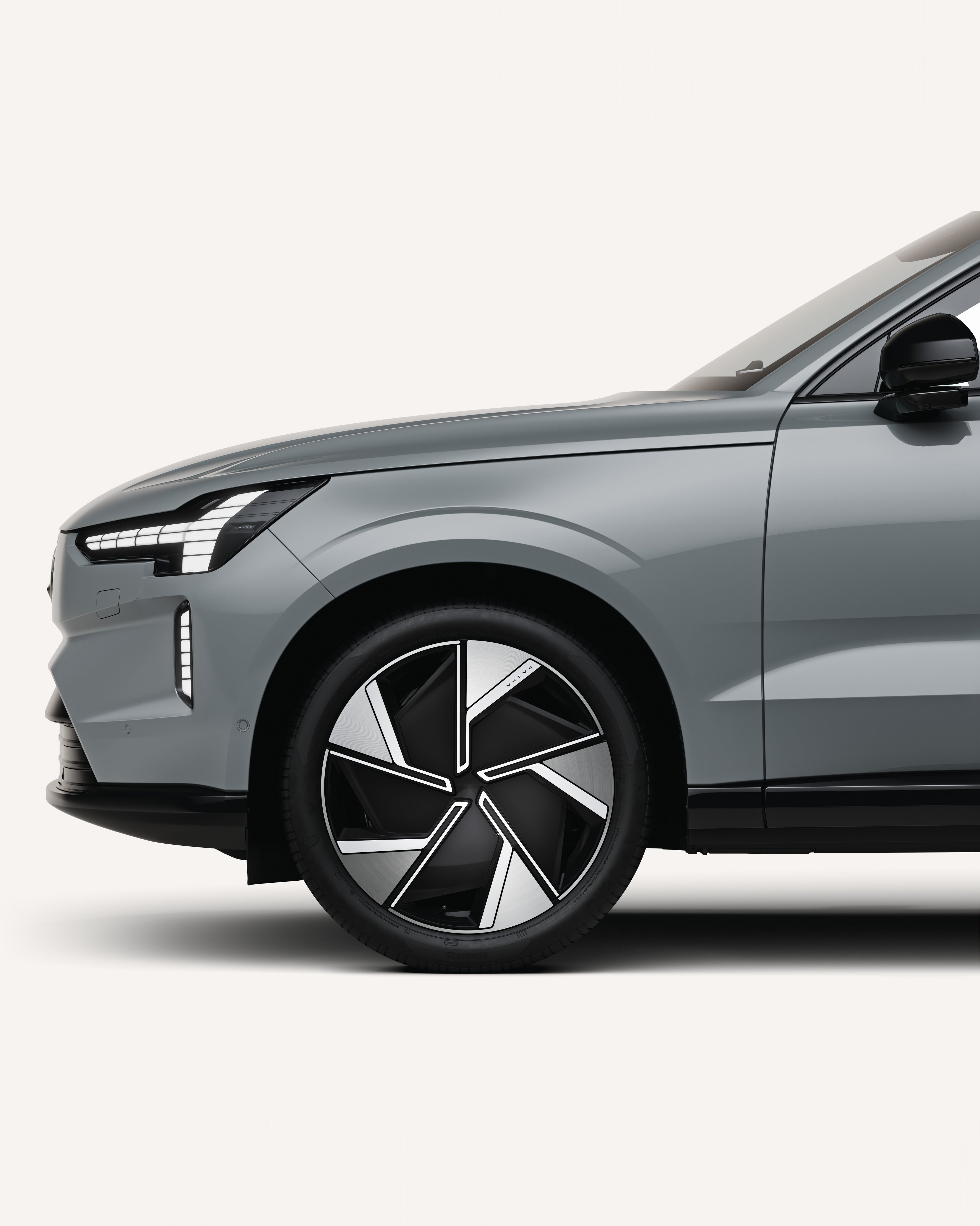 Moitié avant de la Volvo EX90 dans un studio blanc.