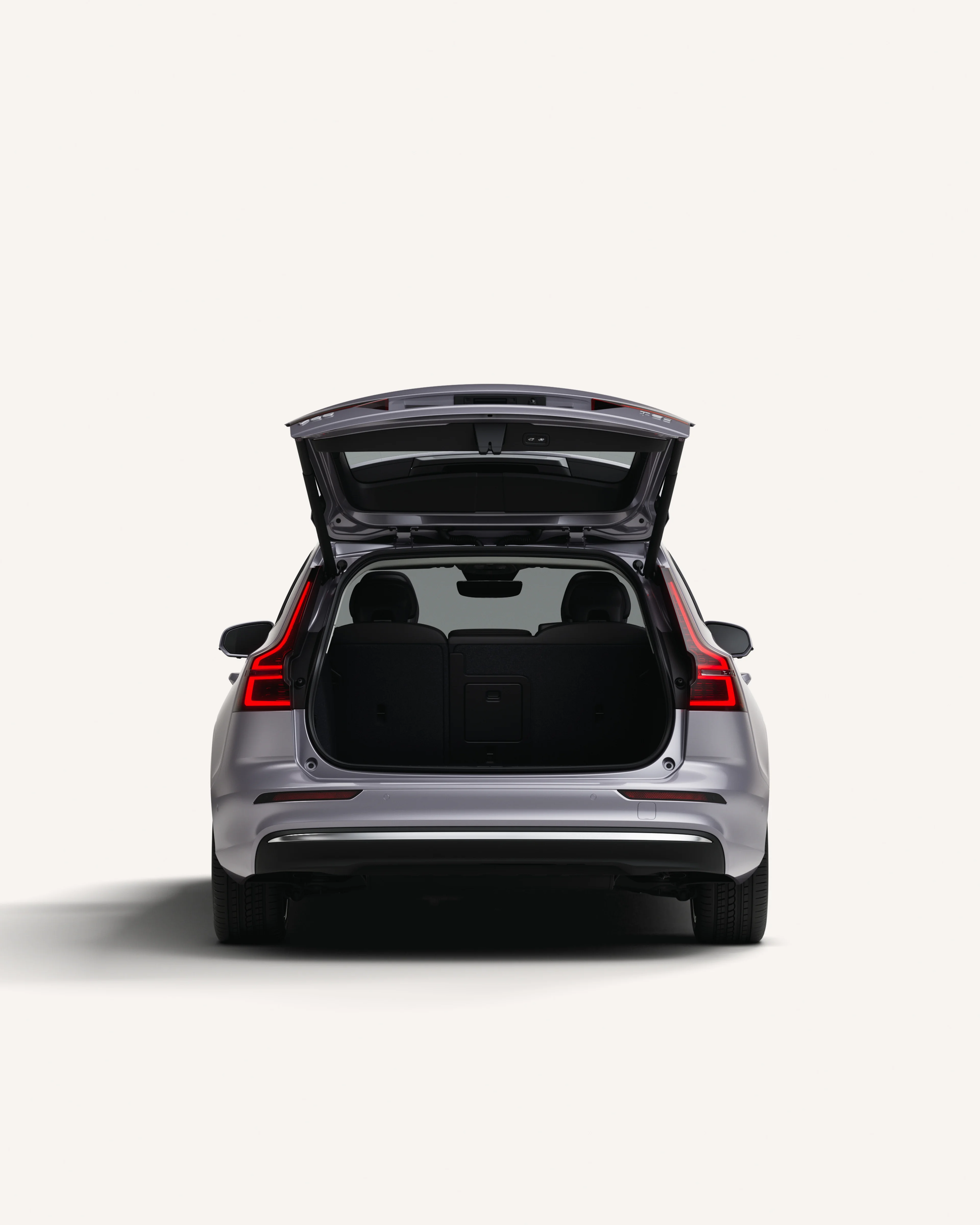Heckansicht des Volvo V60 mit geöffnetem Kofferraum in einer weißen Studioumgebung.