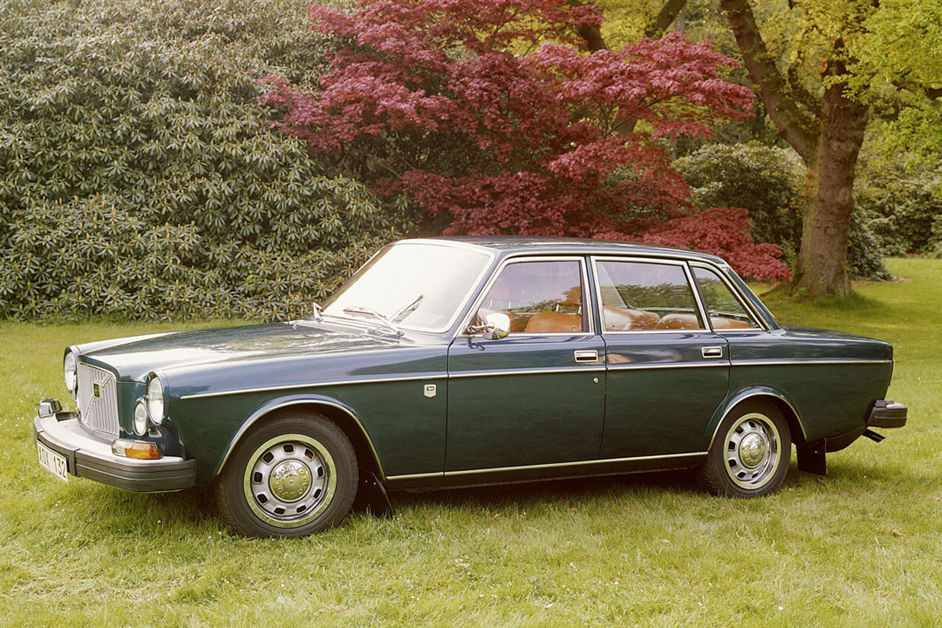 Un Volvo 164 verde aparcado en un aparcamiento.