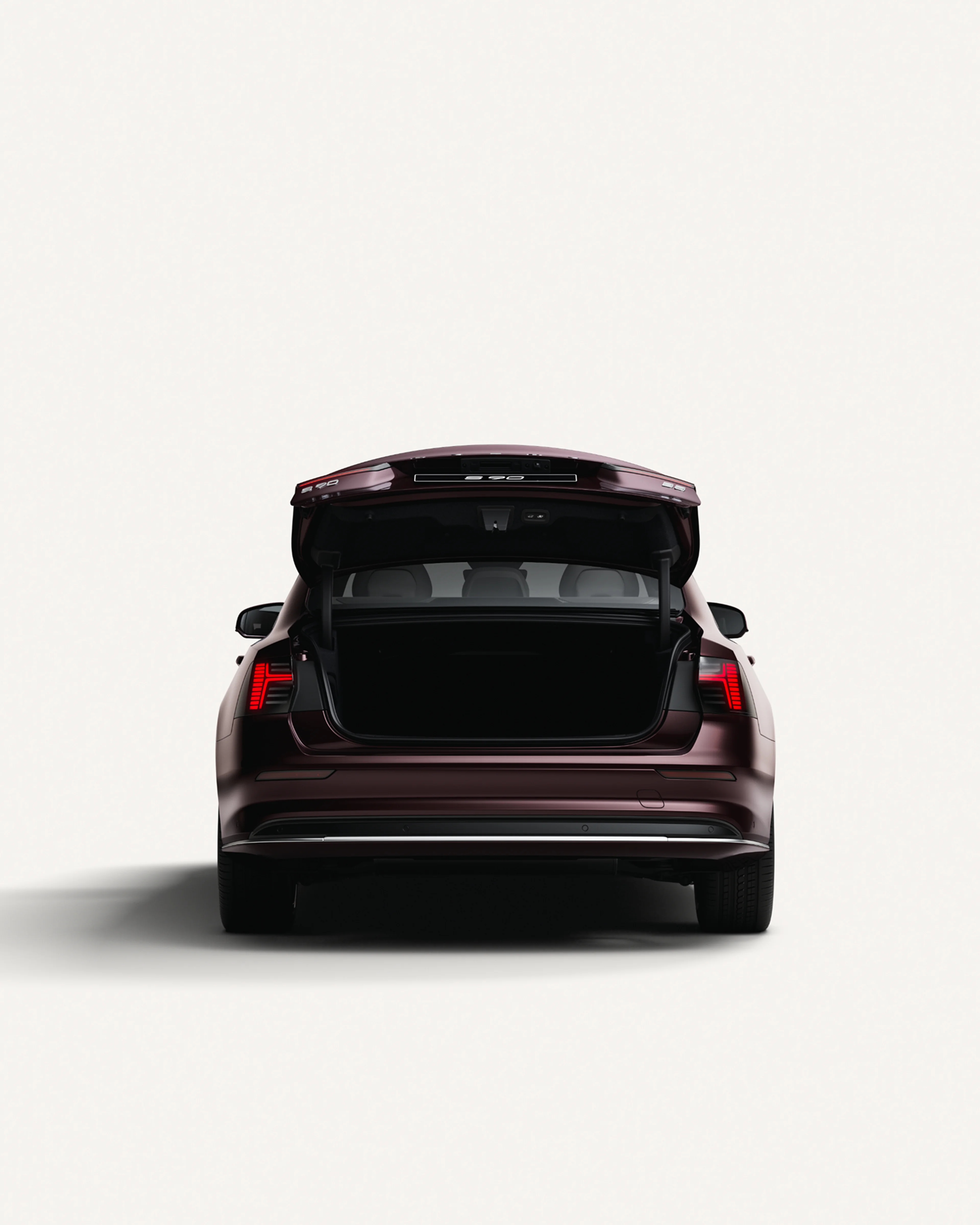 Rear view of the Volvo S90 with the trunk open in a white studio environment.