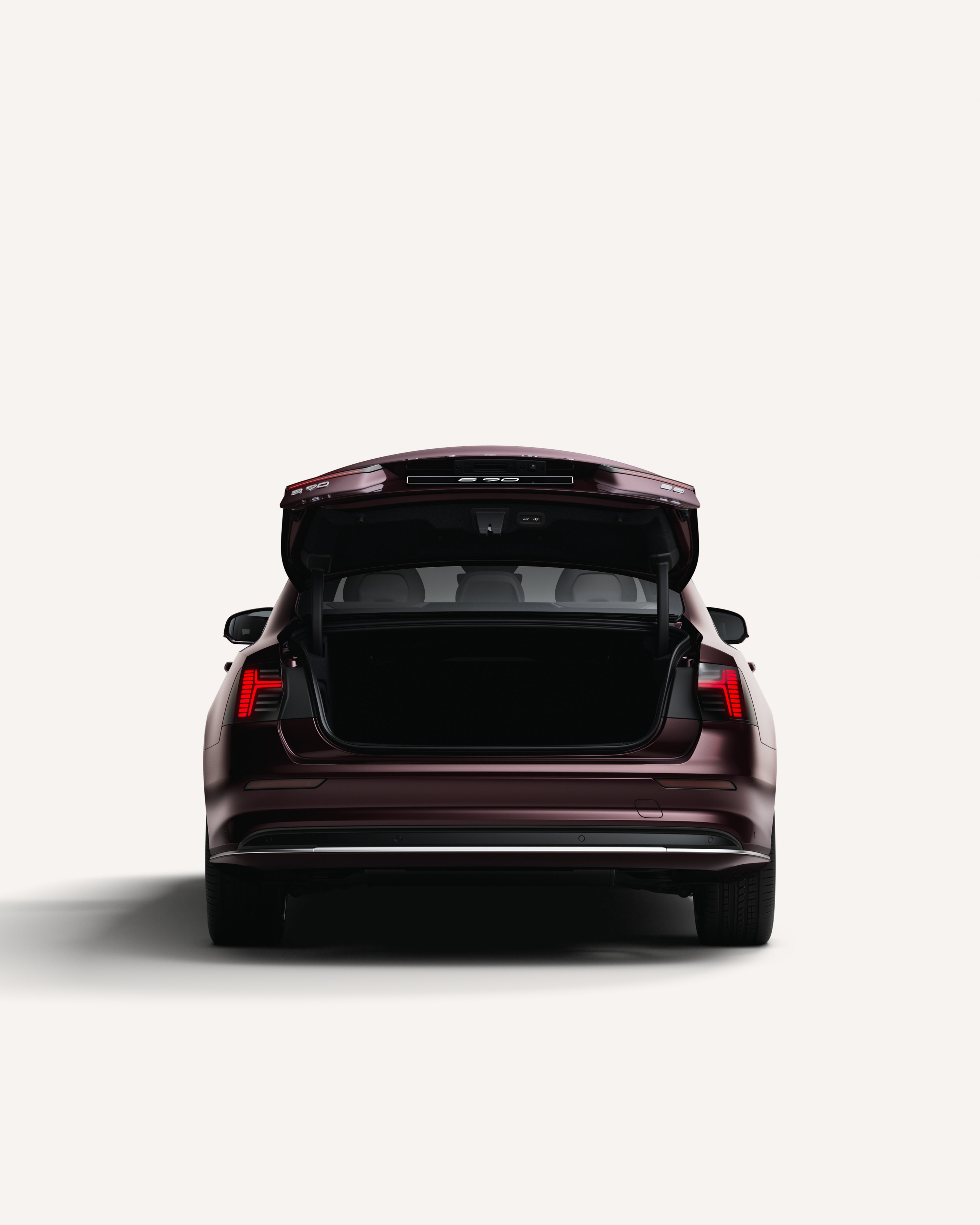 흰색 스튜디오 환경에서 트렁크가 열린 Volvo S90 의 후면도.