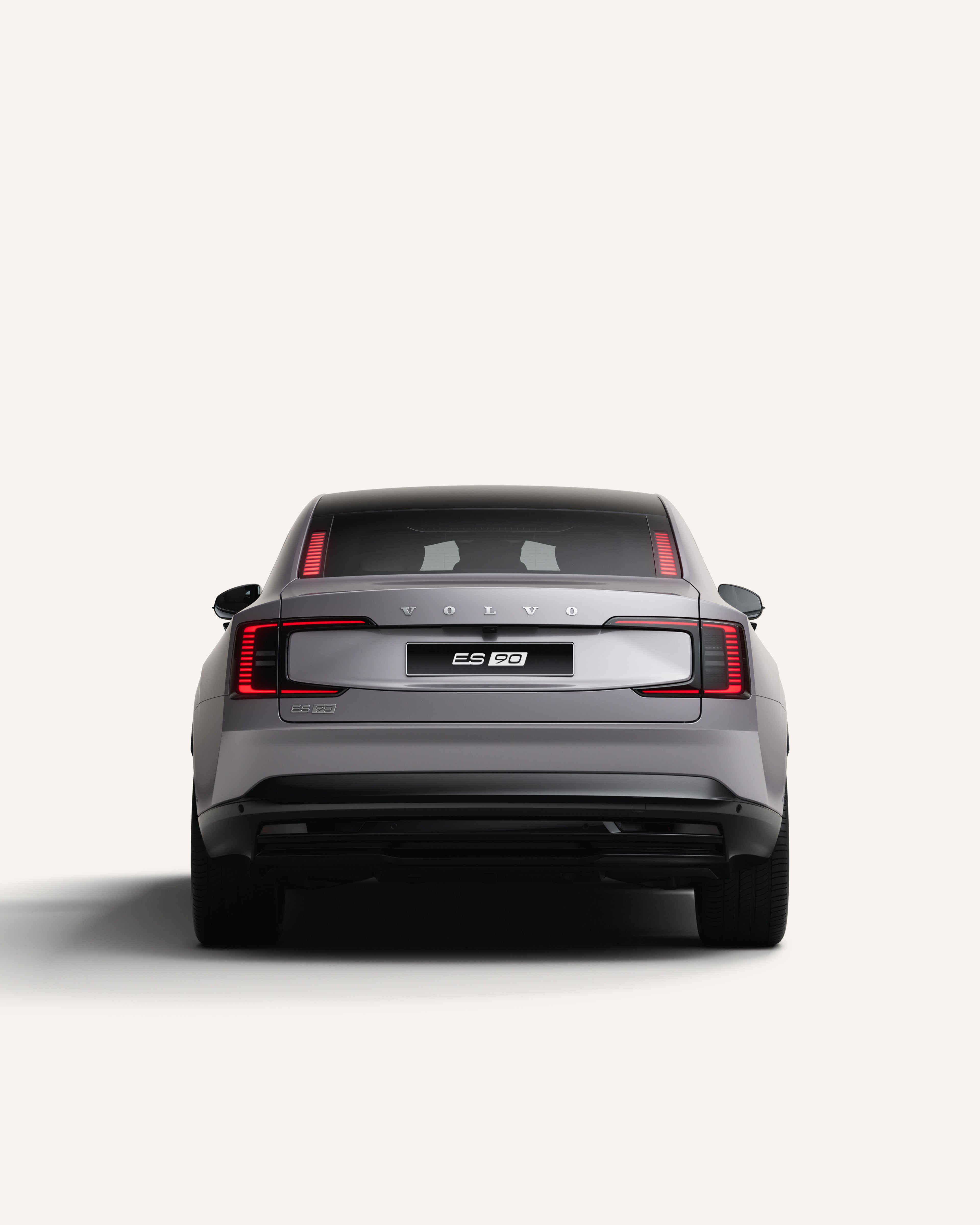 Вид сзади на полностью электрический Volvo ES90 с гладкими задними фонарями.
