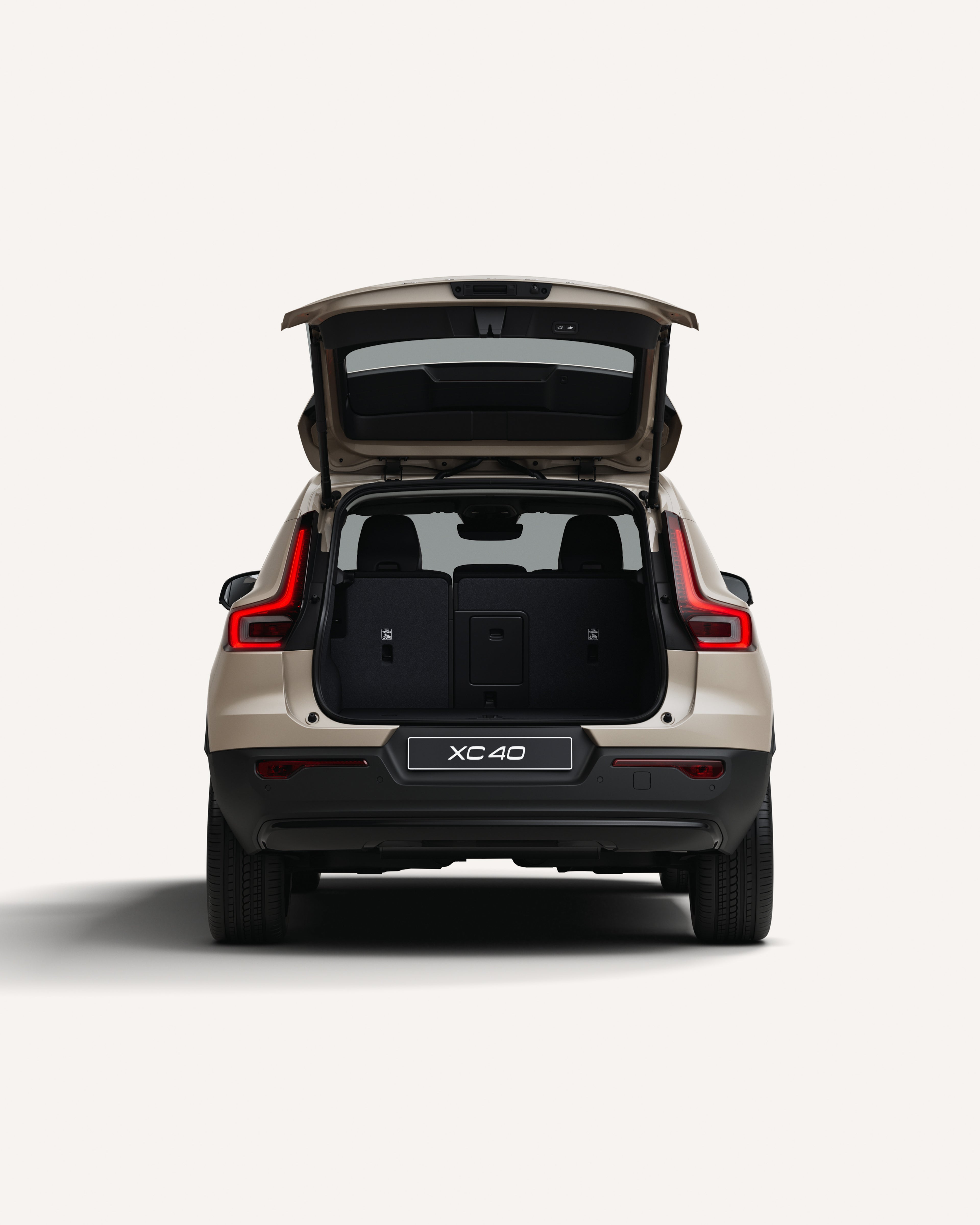 Πίσω όψη του Volvo XC40 με τον χώρο αποσκευών ανοιχτό σε λευκό περιβάλλον στούντιο.