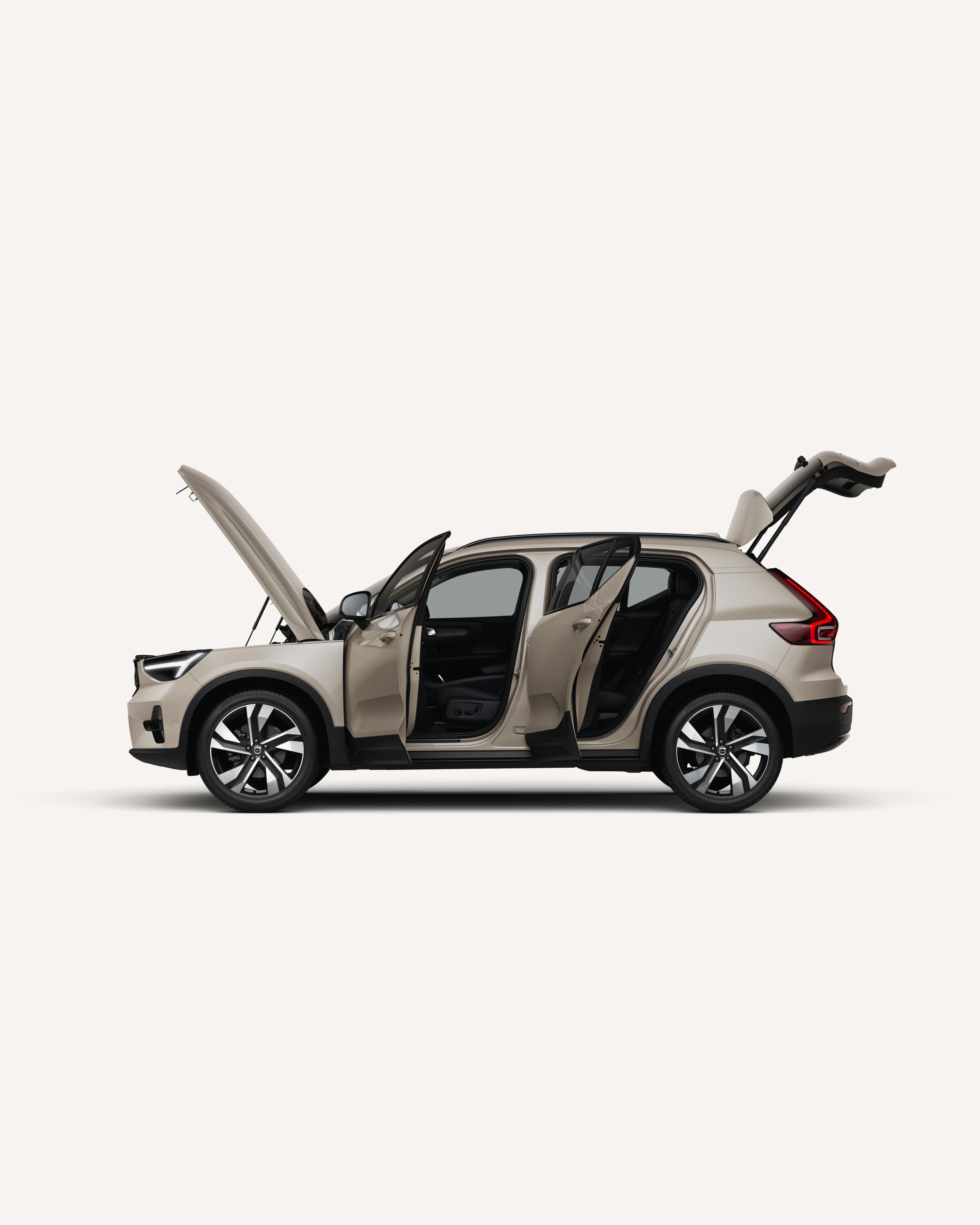 Side view of the Volvo XC40 mild hybrid SUV with open hood, doors, and trunk in a white studio environment.
