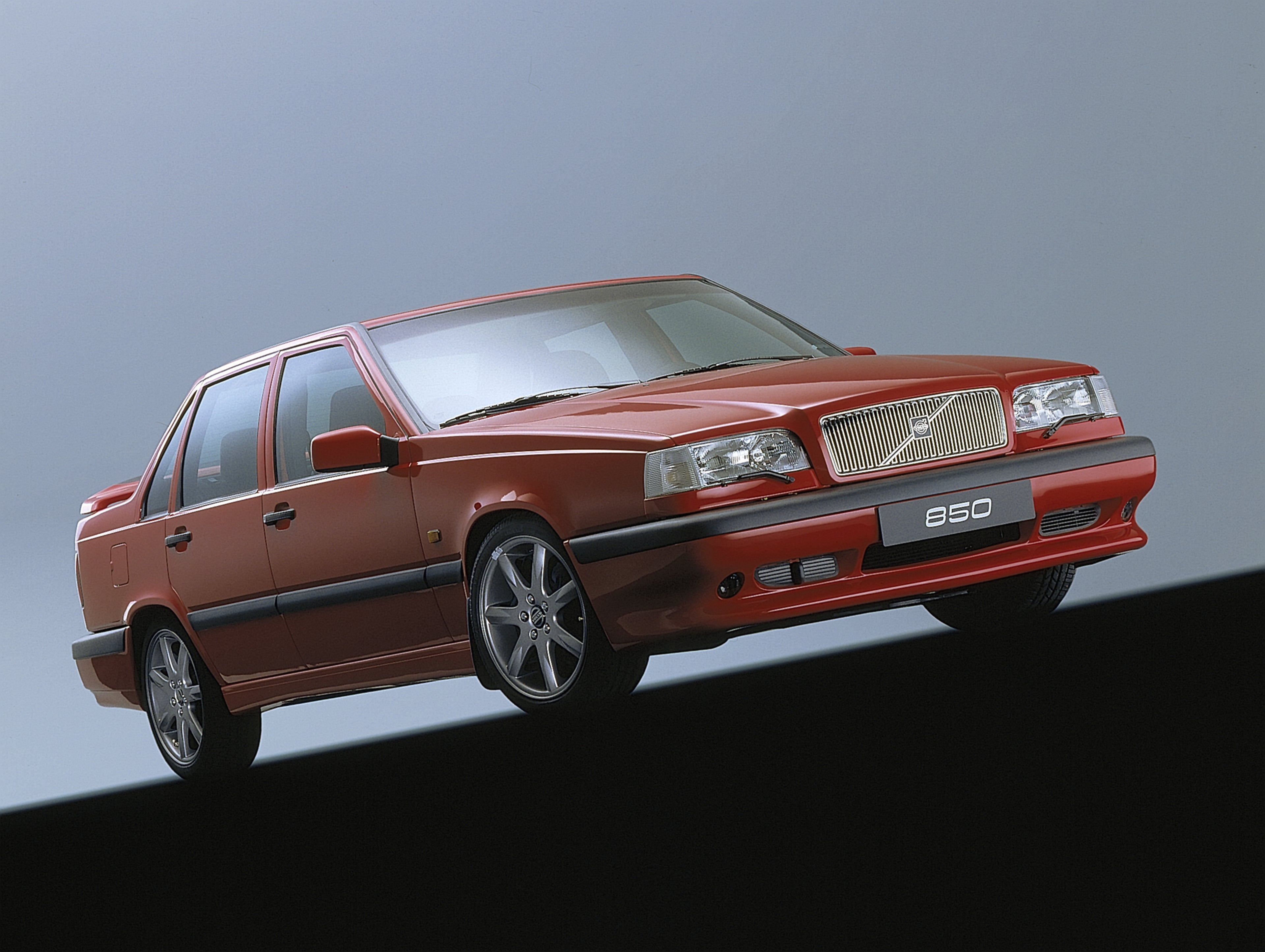 Volvo 850 jaune garée devant un champ de fleurs jaunes.