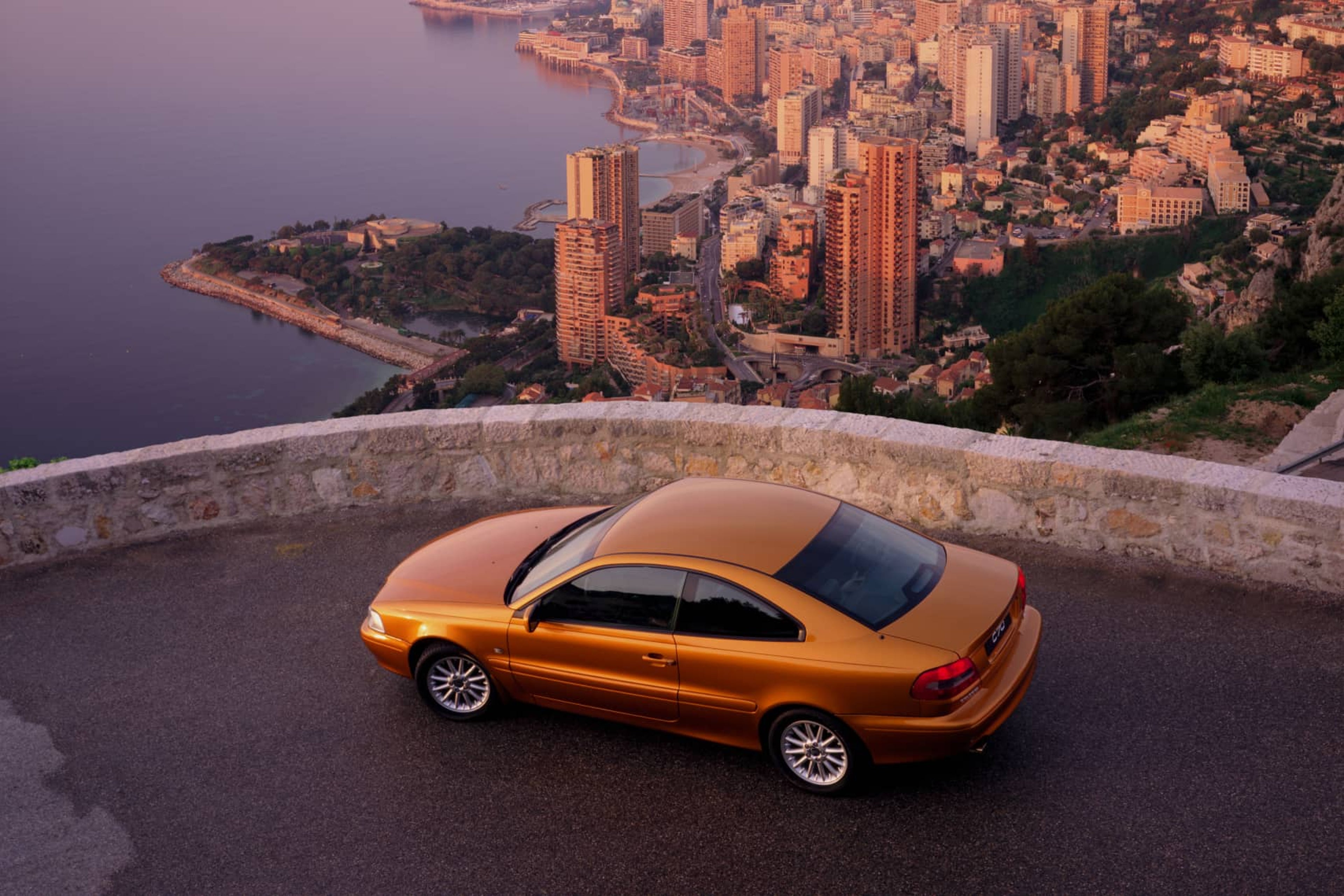 Un Volvo C70 fotografiado desde arriba con vistas a una gran ciudad.