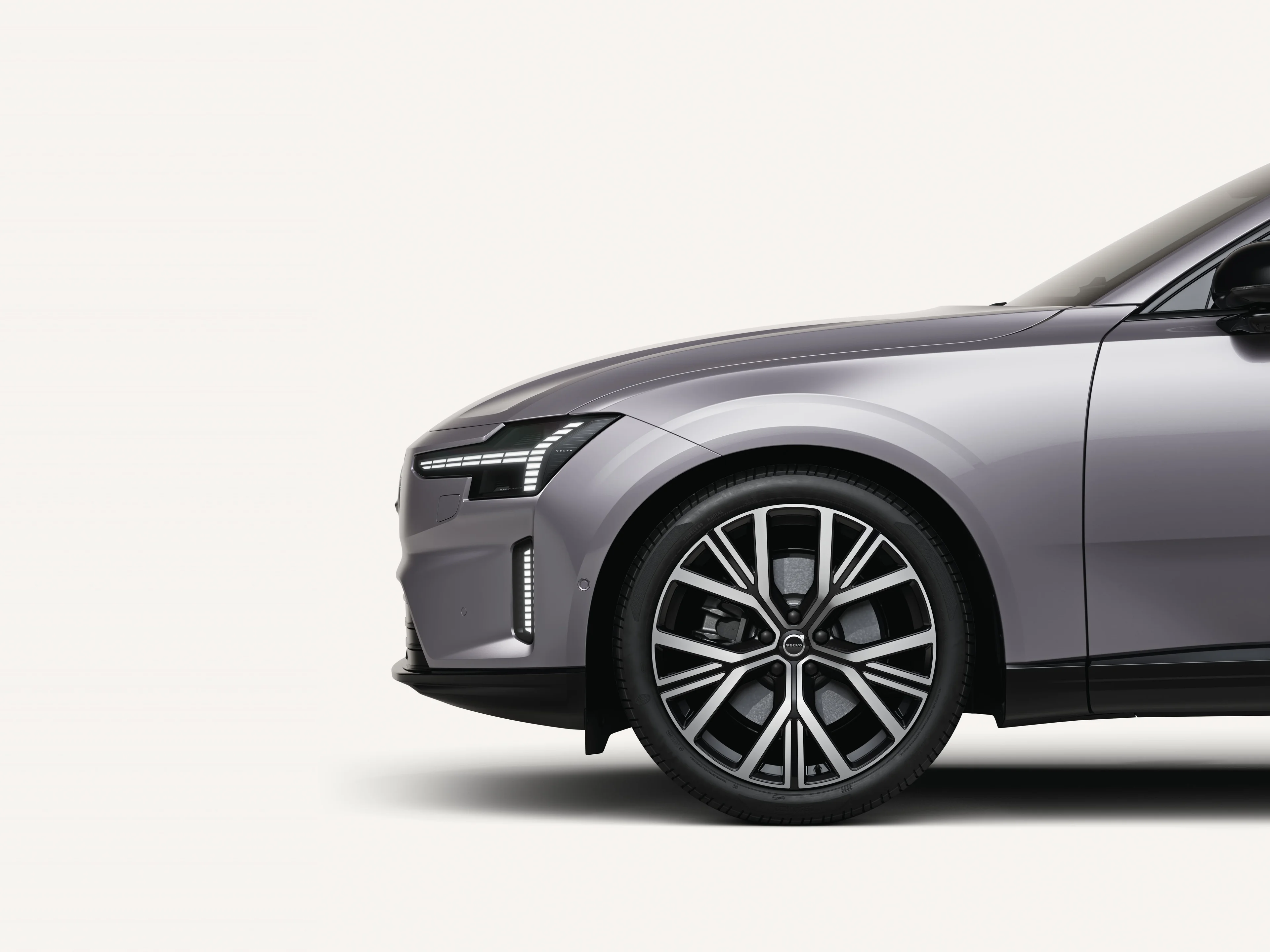 Gros plan sur la roue avant de la Volvo ES90 avec des roues aérodynamiques noires.