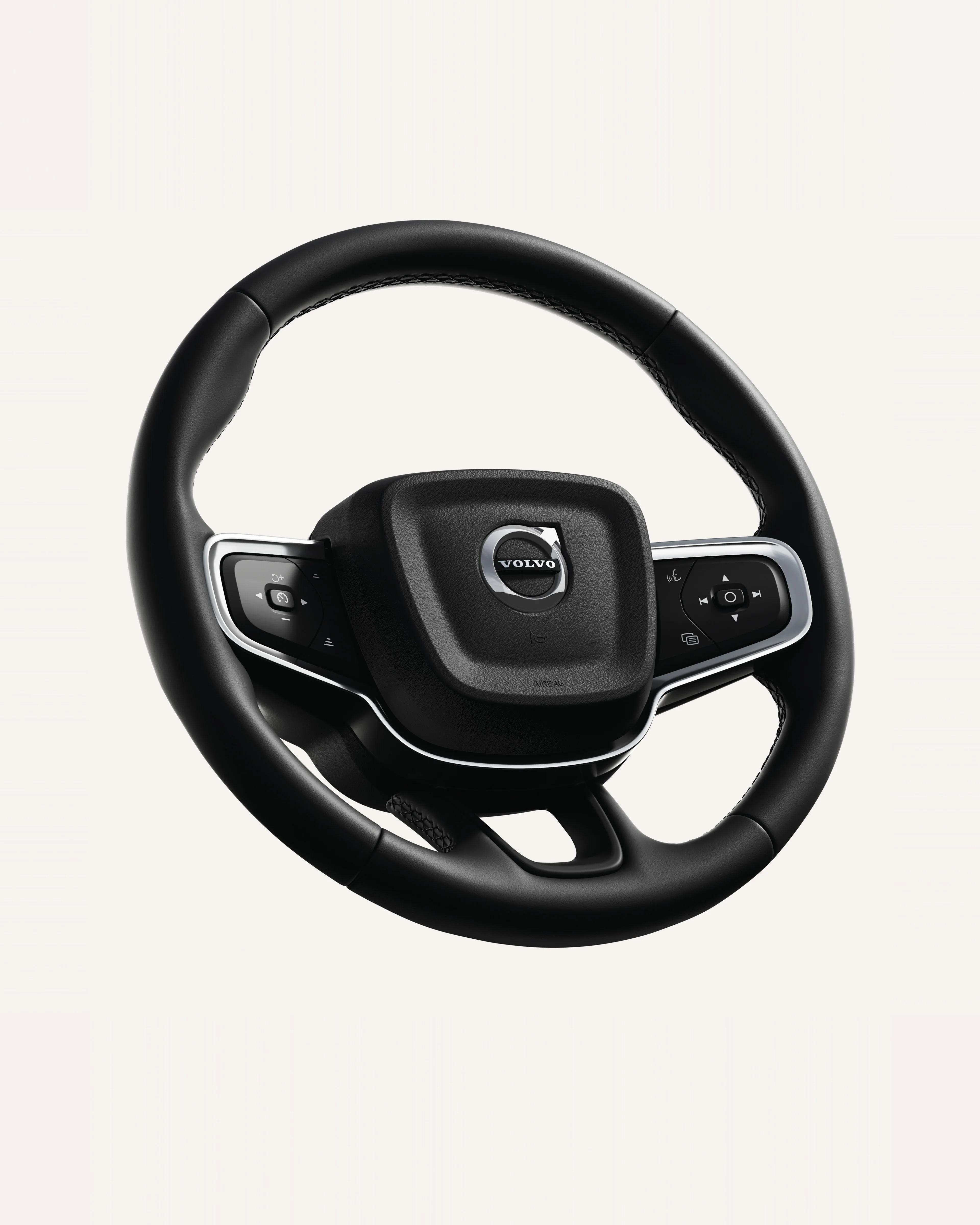 Close-up of the Volvo XC40 steering wheel, featuring integrated controls in a white studio environment.