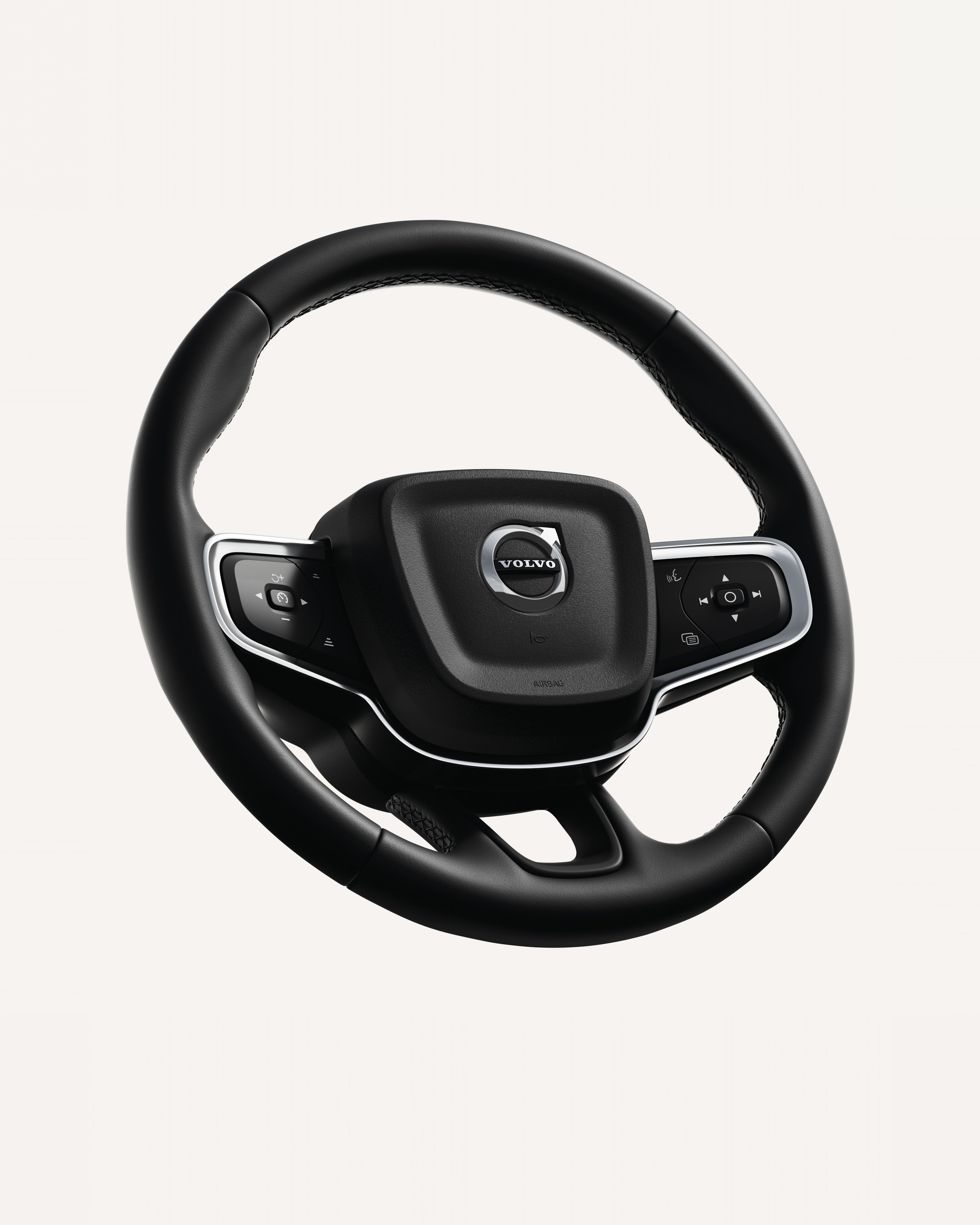 Крупен план на воланот на Volvo XC40, со интегрирани контроли во бела студиска средина.