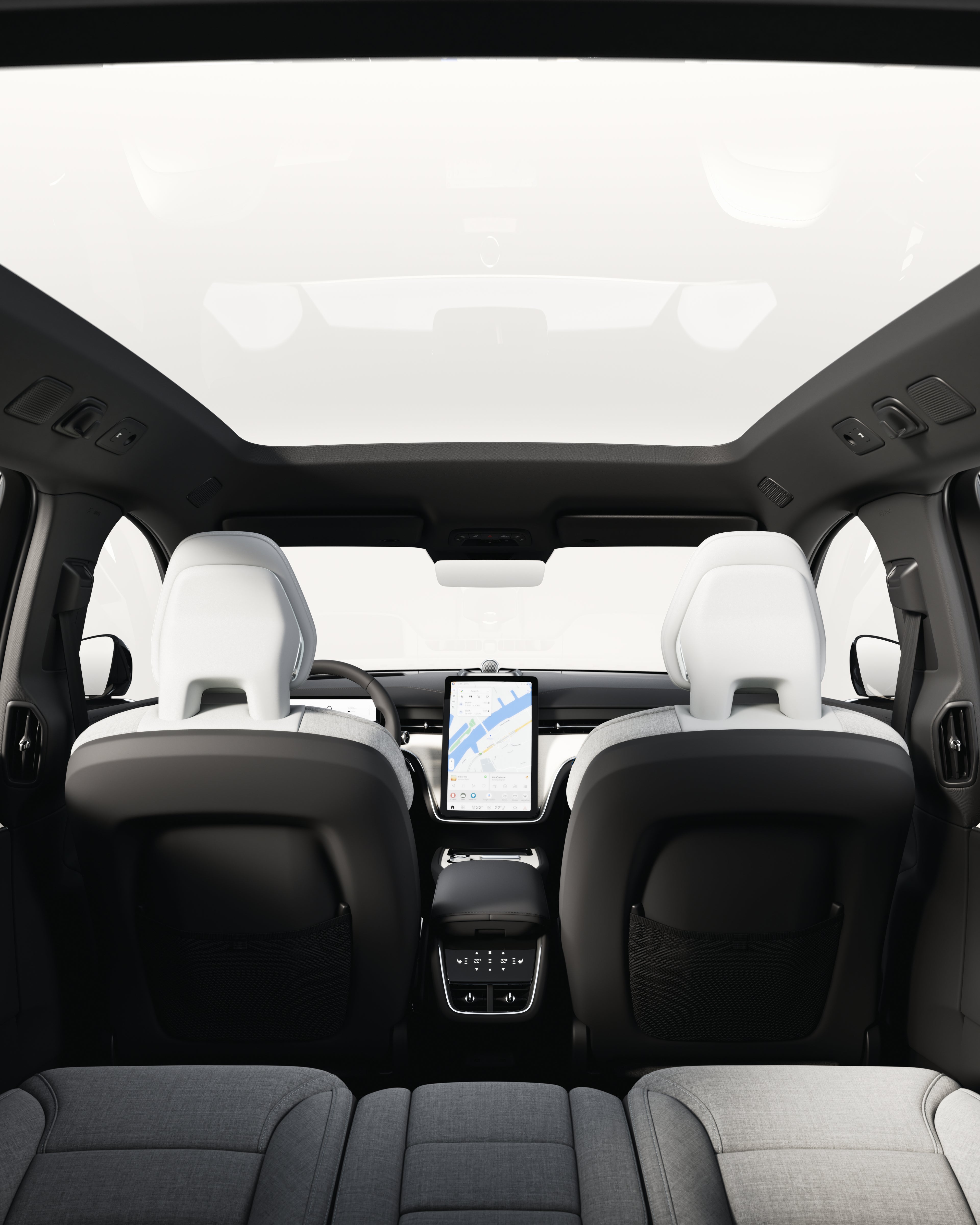 Cabin overview of the Volvo EX90 highlighting the panoramic roof from a rear seat perspective.