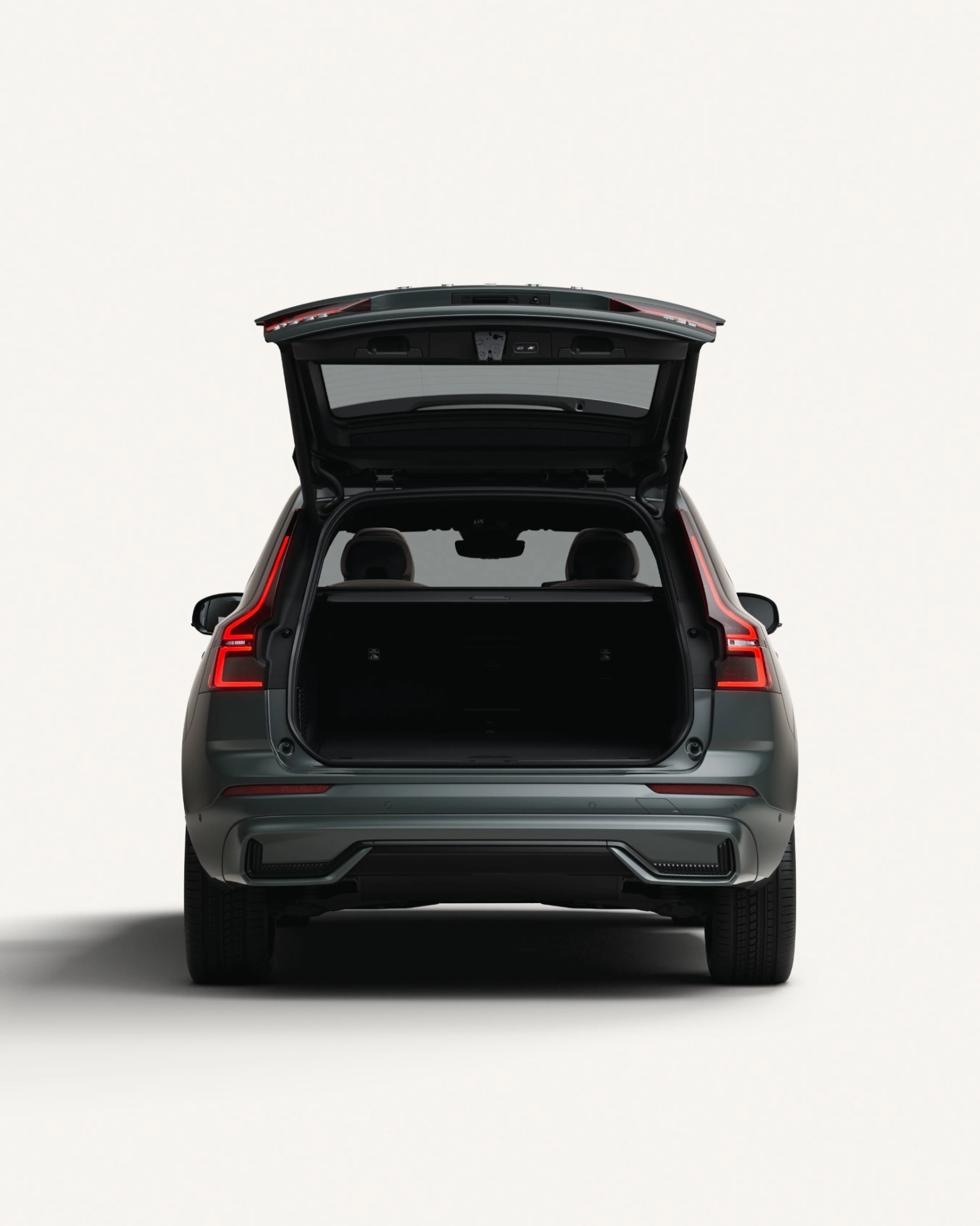 The open rear load compartment the Volvo XC60 midsize mild hybrid SUV in a white studio environment.