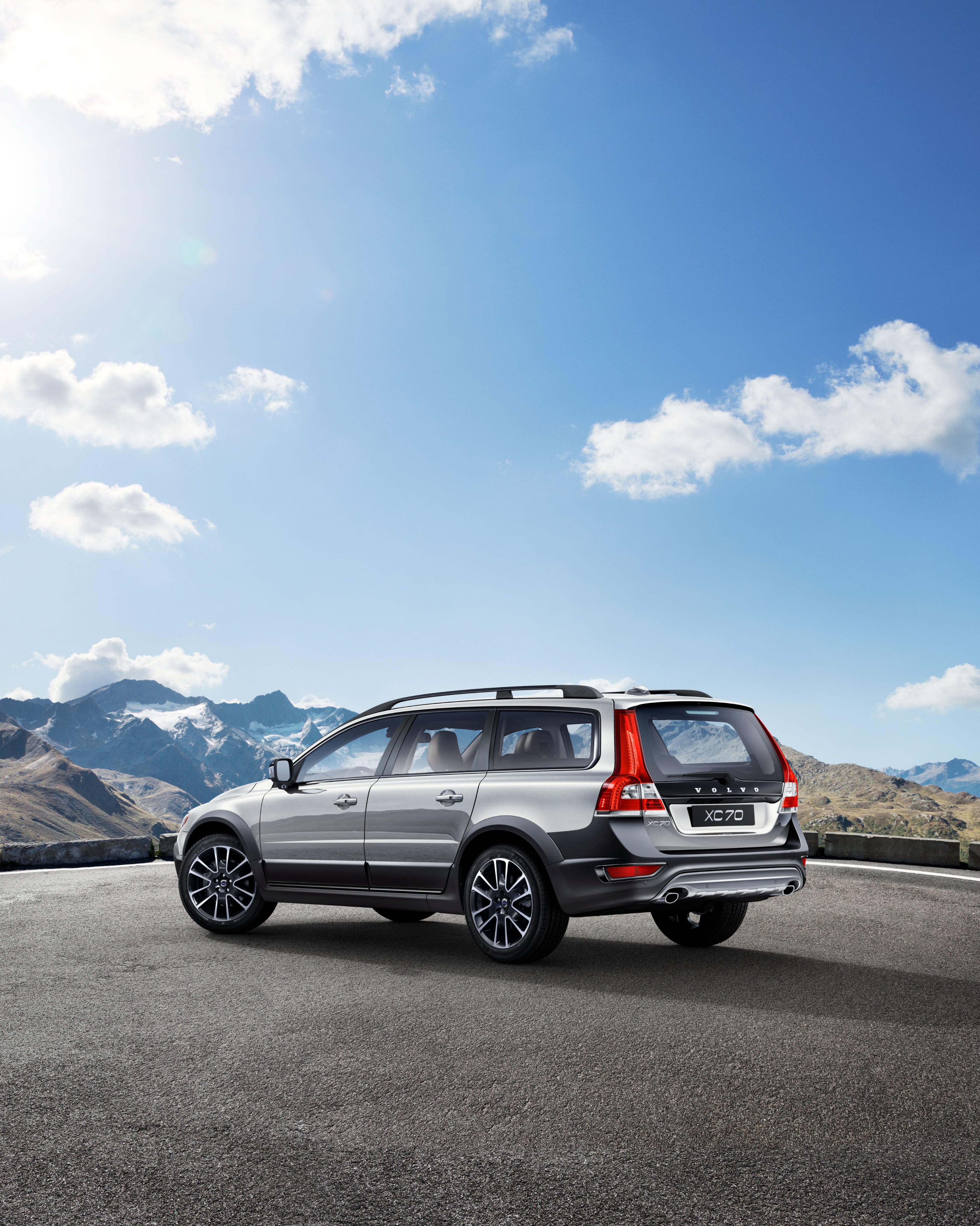 Un coche XC70 aparcado con vistas a unas montañas.