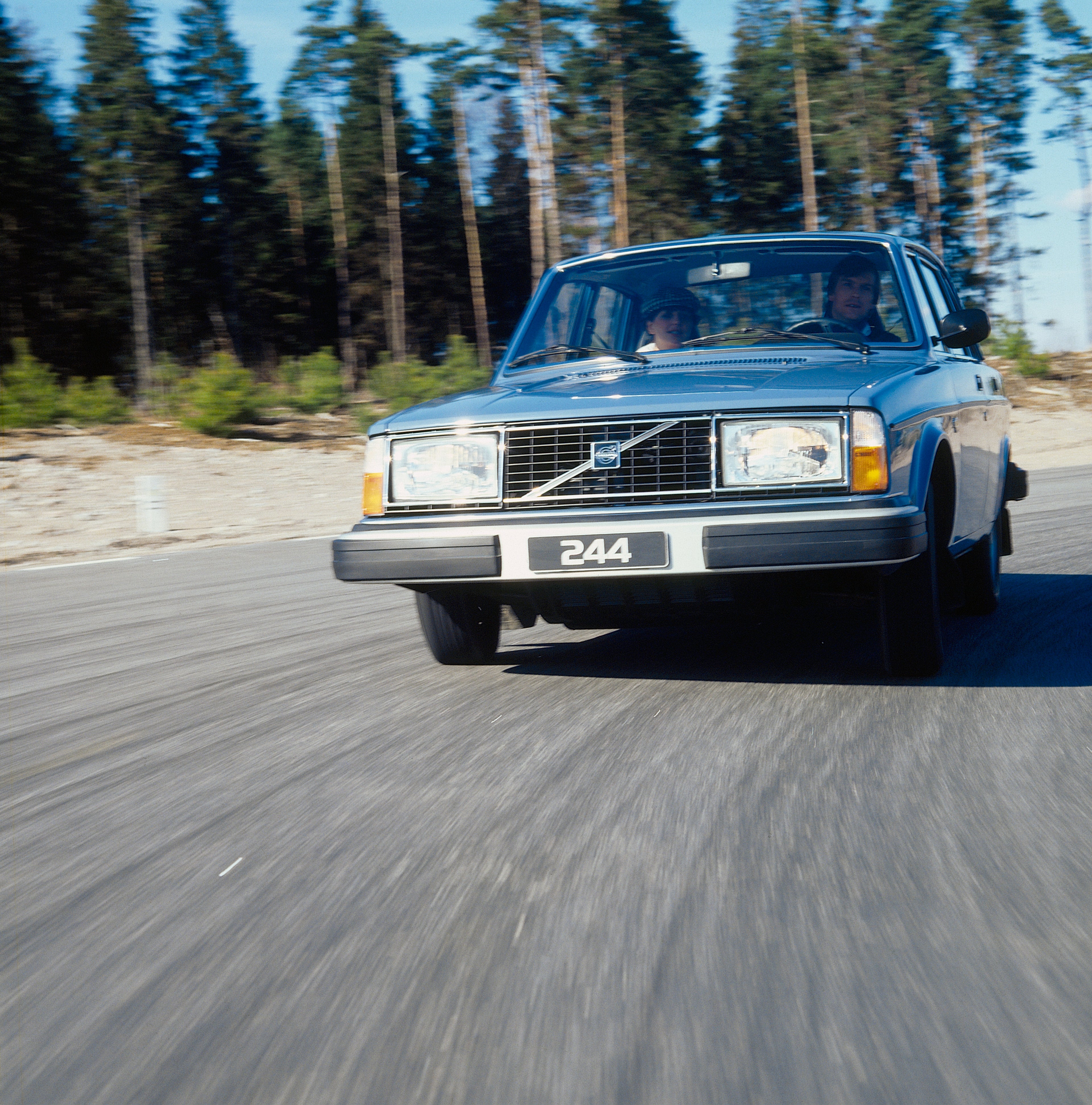 Volvo 244 dans une prairie surplombant le paysage.