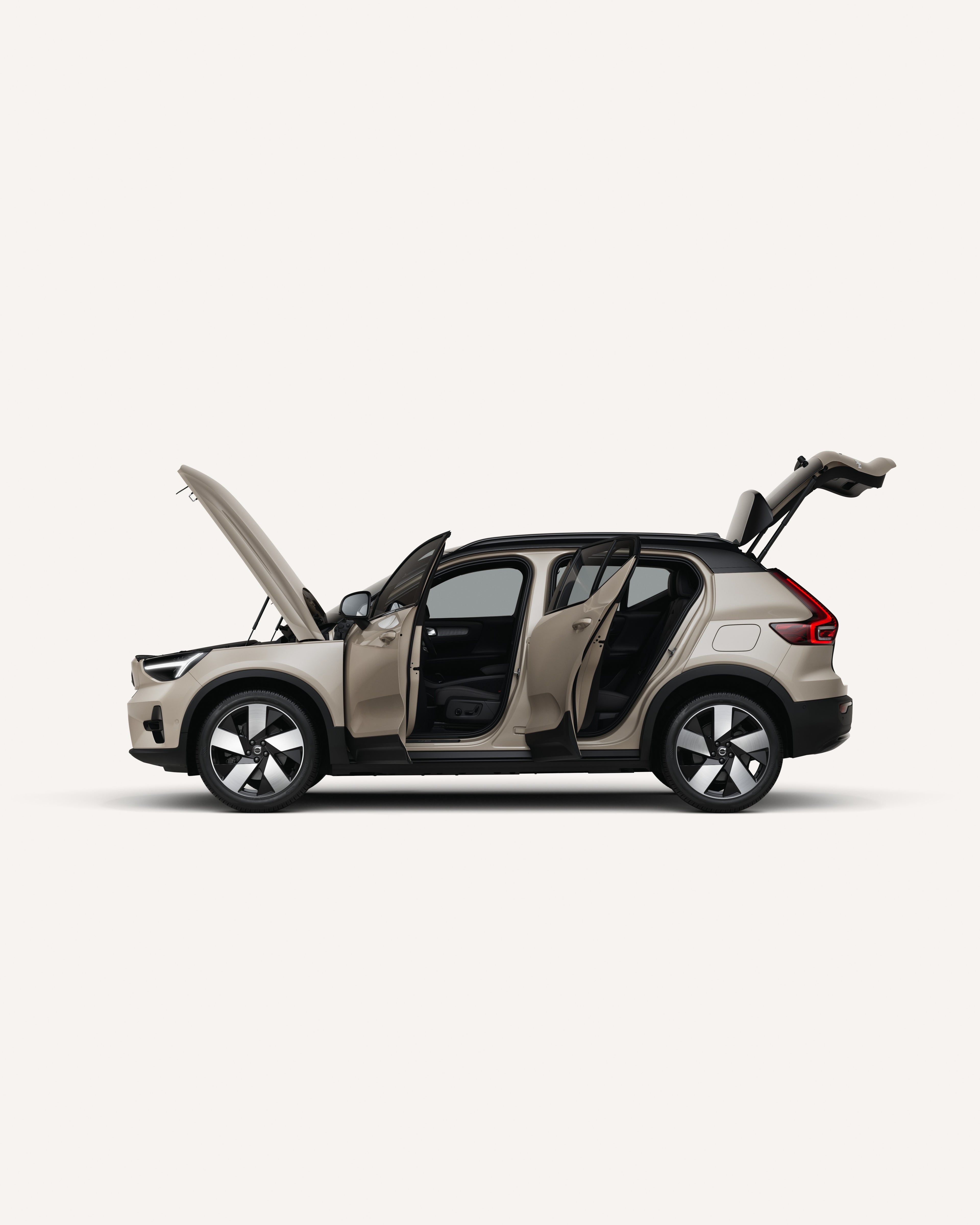 Side view of the Volvo EX40 with open hood, doors, and trunk in a white studio environment.