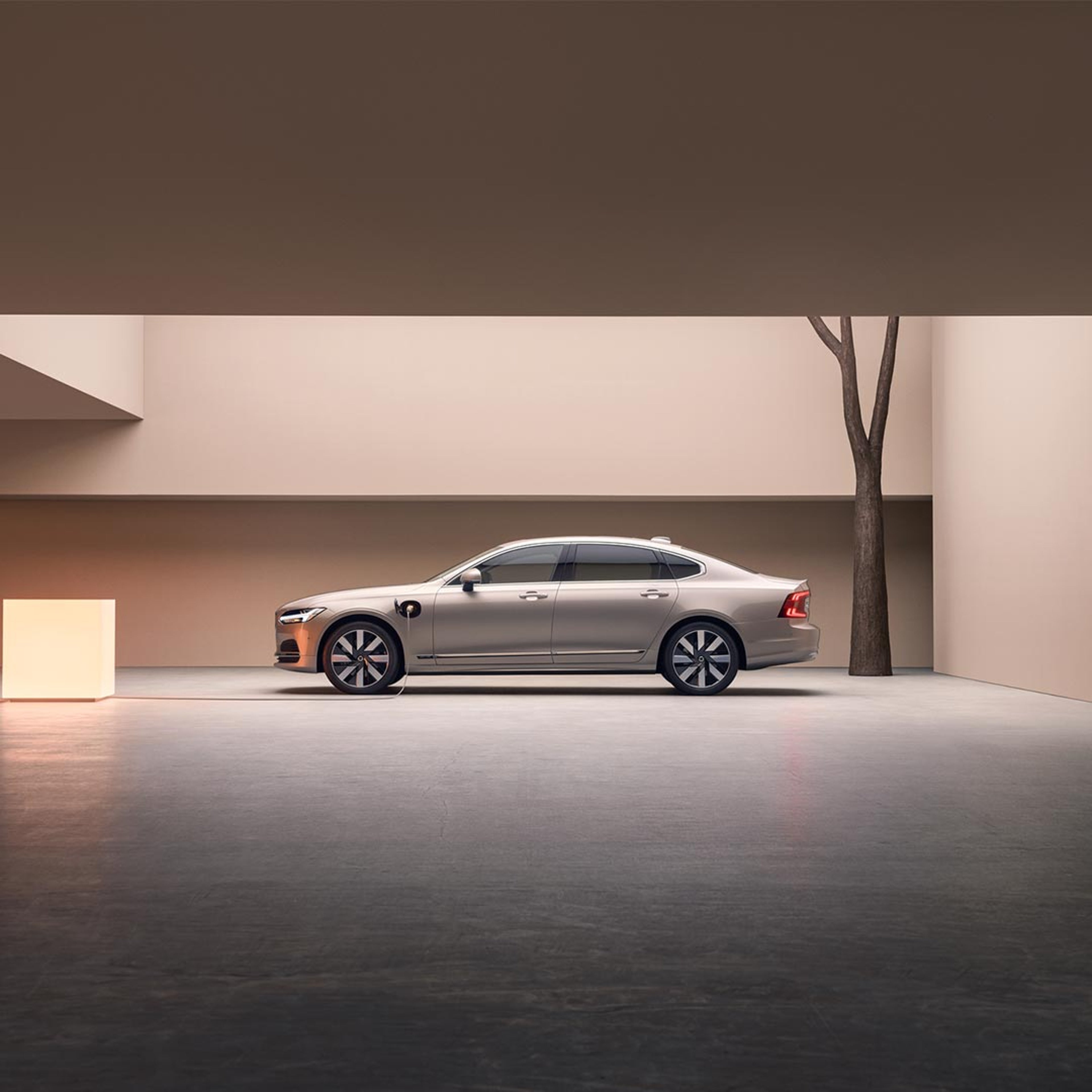 A Volvo S90 Recharge is parked in front of a set of stairs.