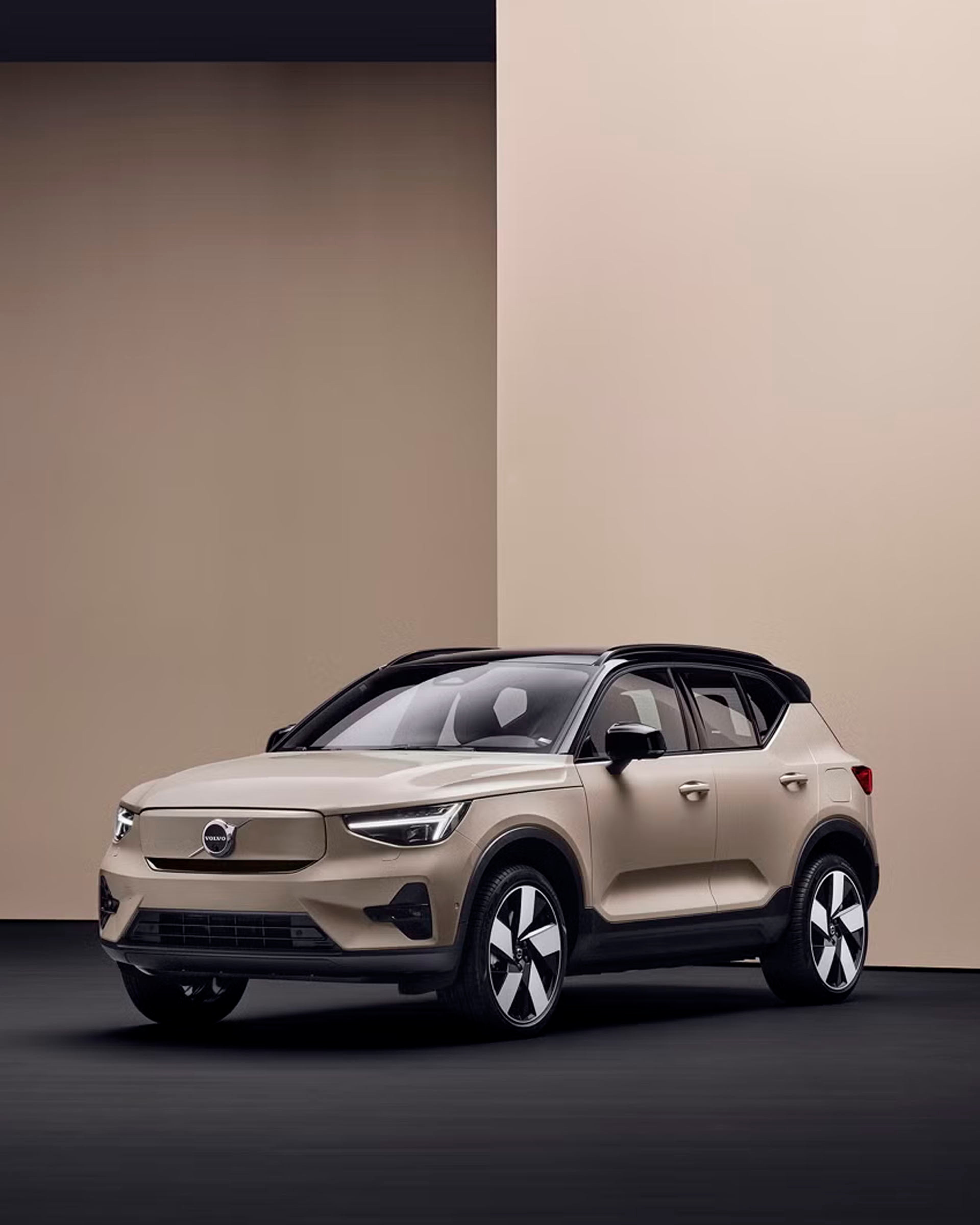Un Volvo EX40 eléctrico destacando sus líneas de diseño en una vista lateral color Sand Dust.