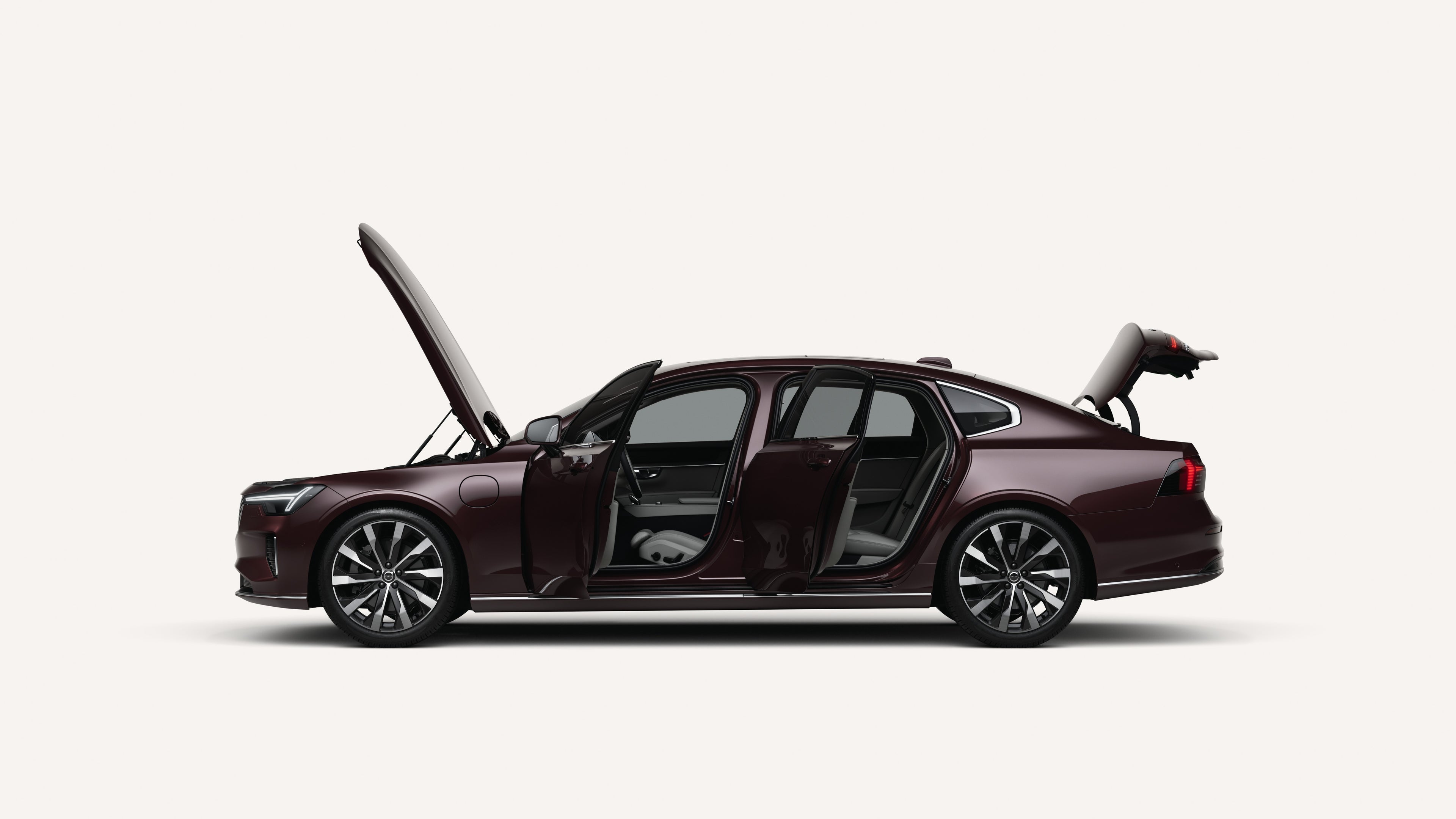 Side view of the Volvo S90 with open hood, doors, and trunk in a white studio environment.