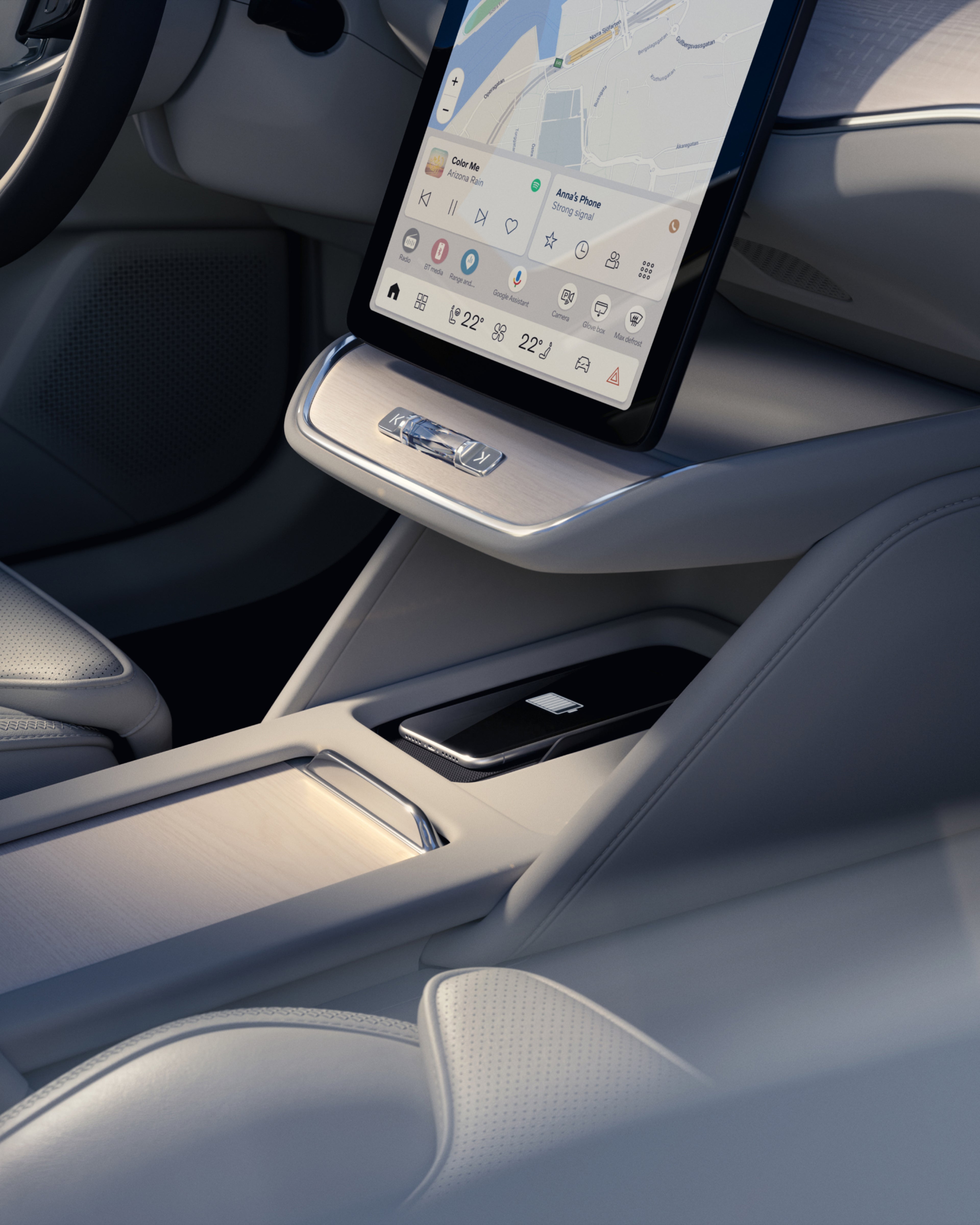Nærbillede af den centrale konsol i Volvo ES90 med berøringsskærm, opbevaringsrum og trådløst mobilopladningssted.