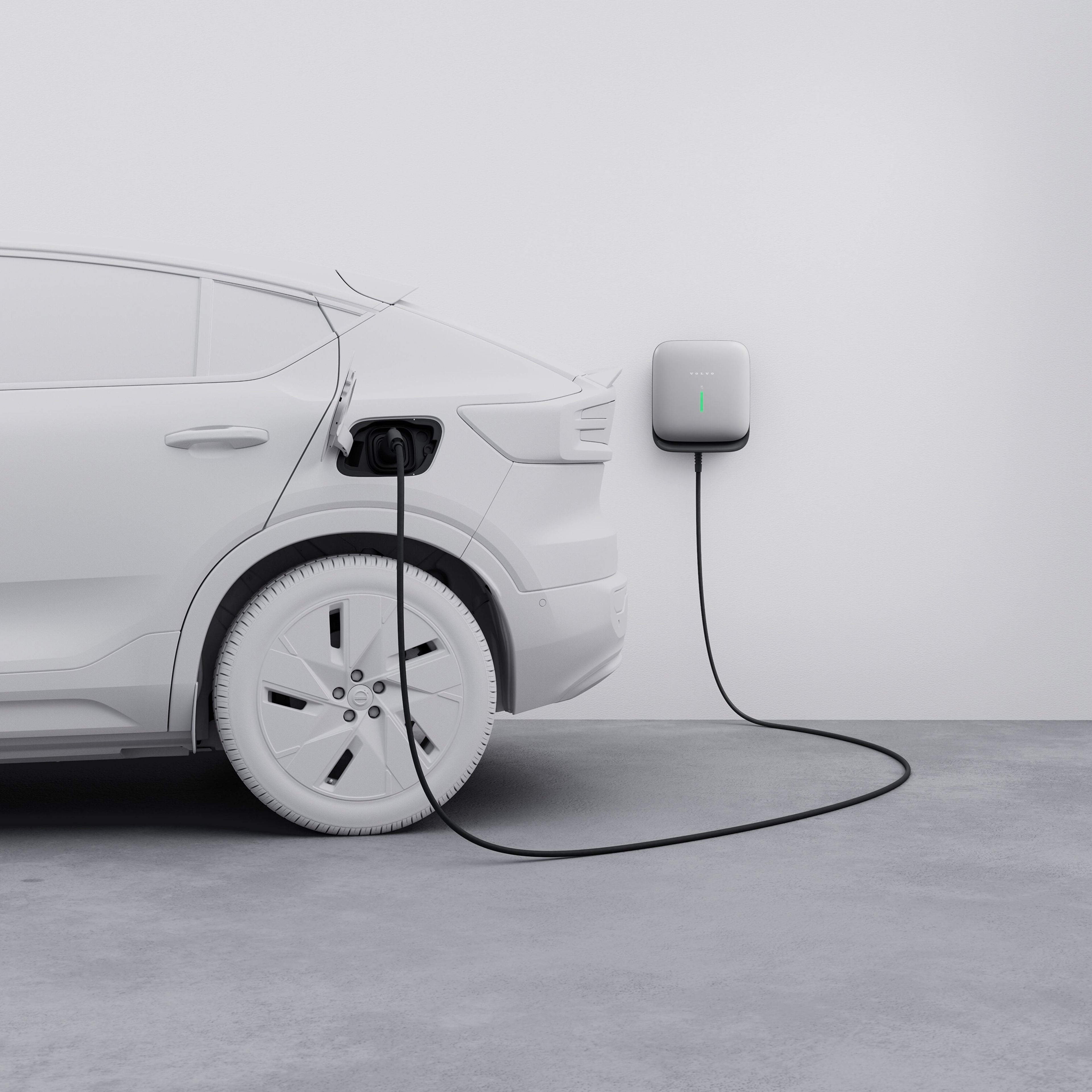Nærbilde bakfra av Volvo EC40, med en ladekabel koblet til en Volvo Cars veggboks.
