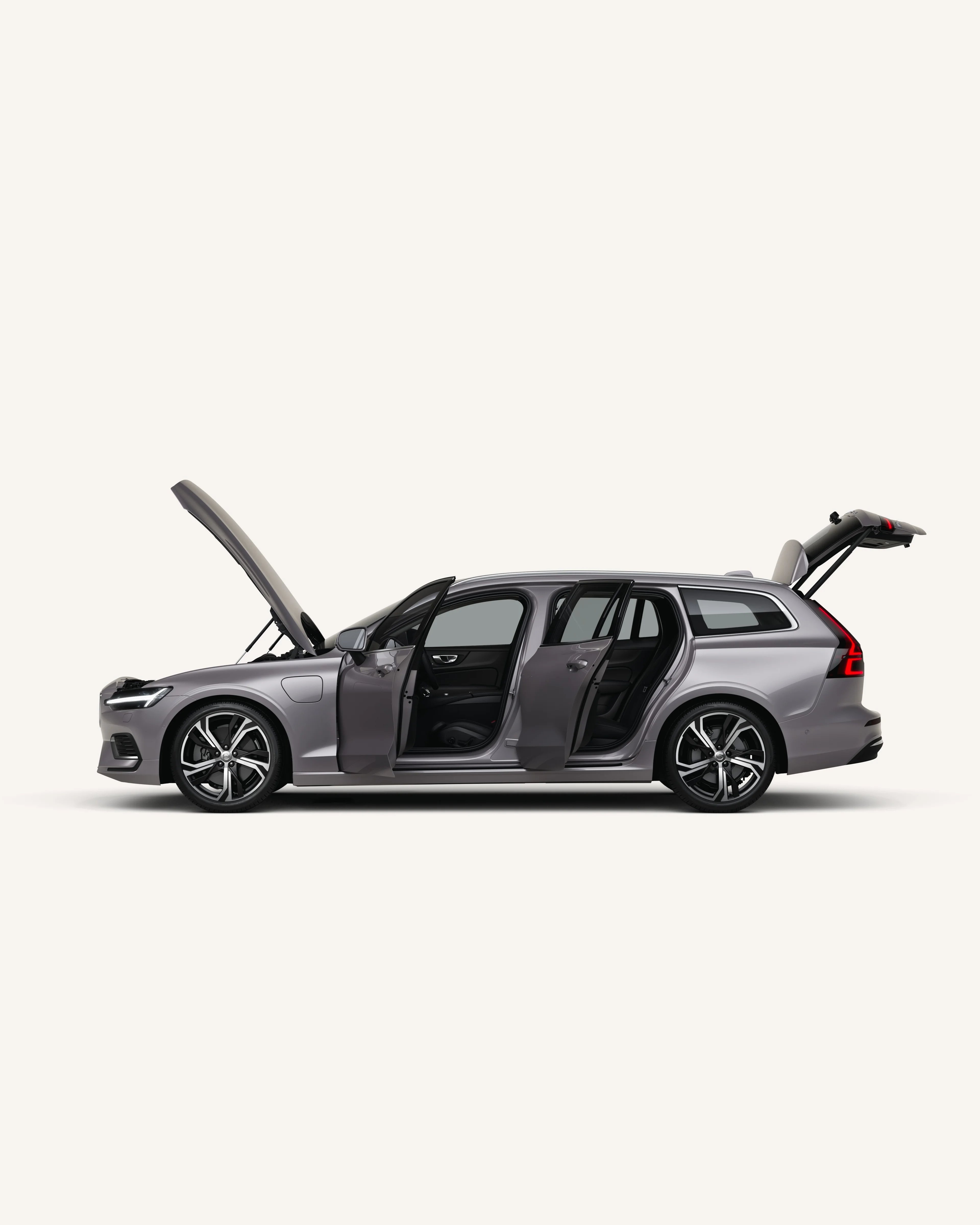 Seitenansicht des Volvo V60 mit geöffneter Motorhaube, Türen und Kofferraum in einer weißen Studioumgebung.
