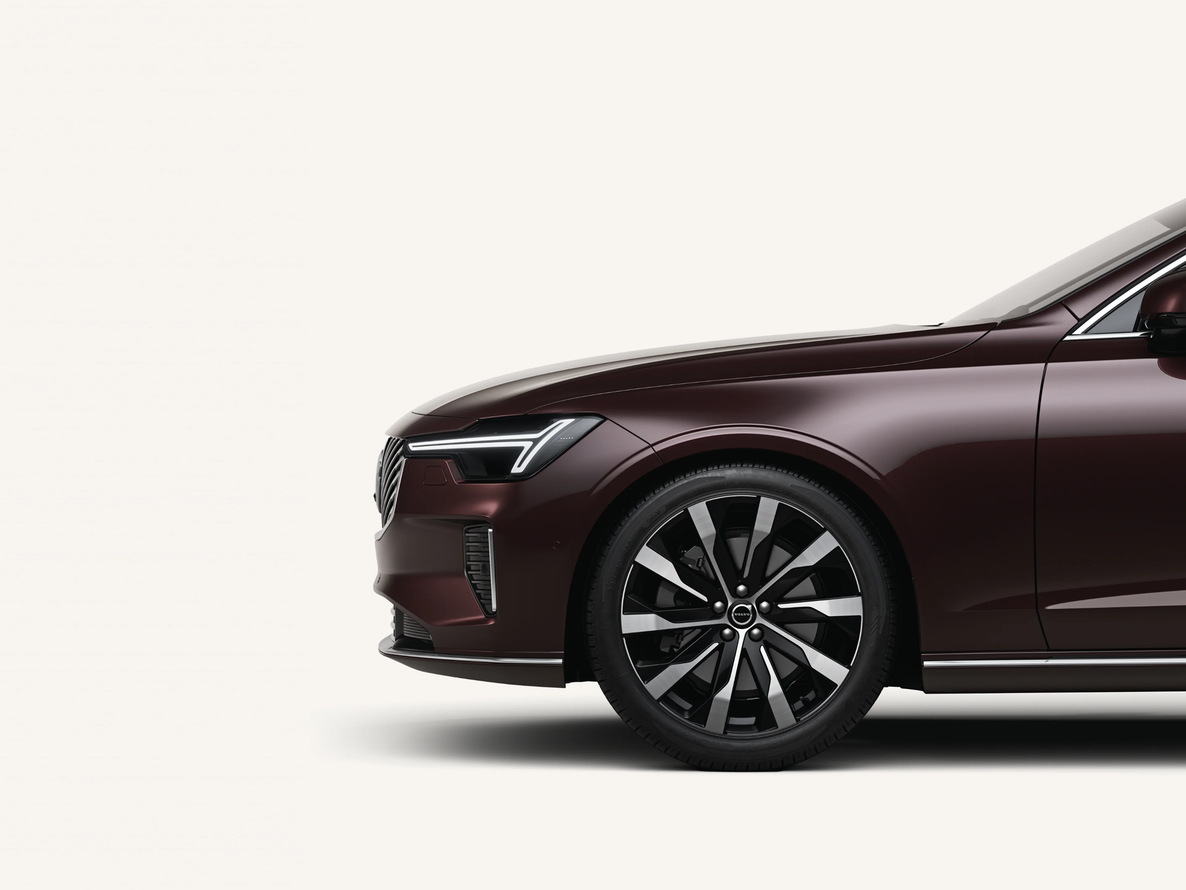 Front half of the Volvo S90 in a white studio environment.