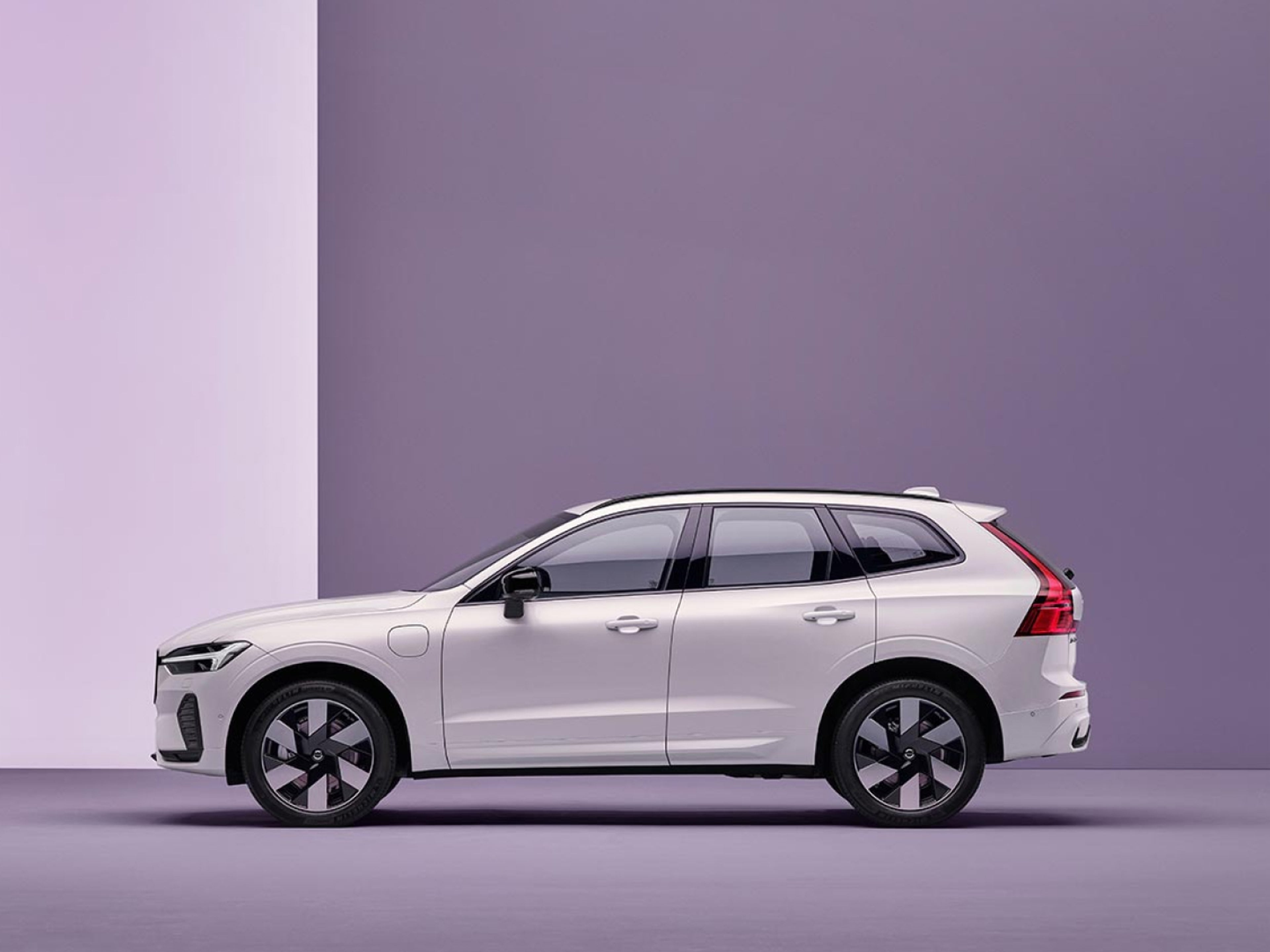 A Volvo XC60 plug-in hybrid, charging in a purple surrounding.