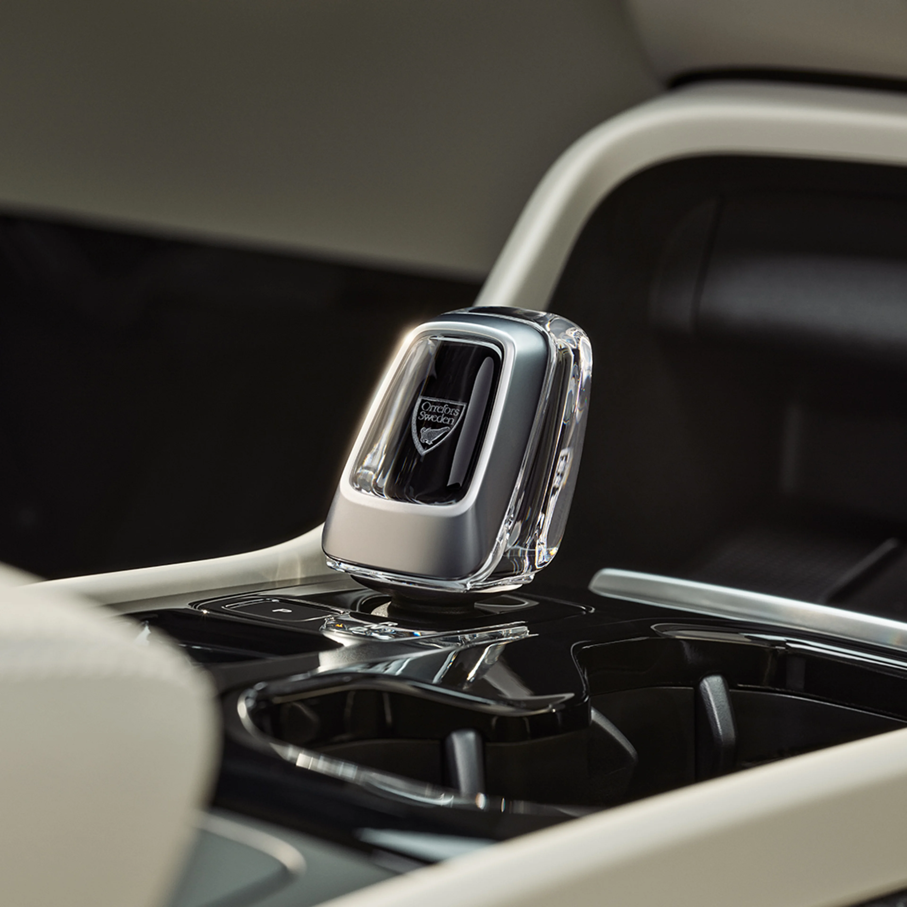 Detalle de la palanca de cambios de cristal en la consola central negra brillante del Volvo XC40 semihíbrido.