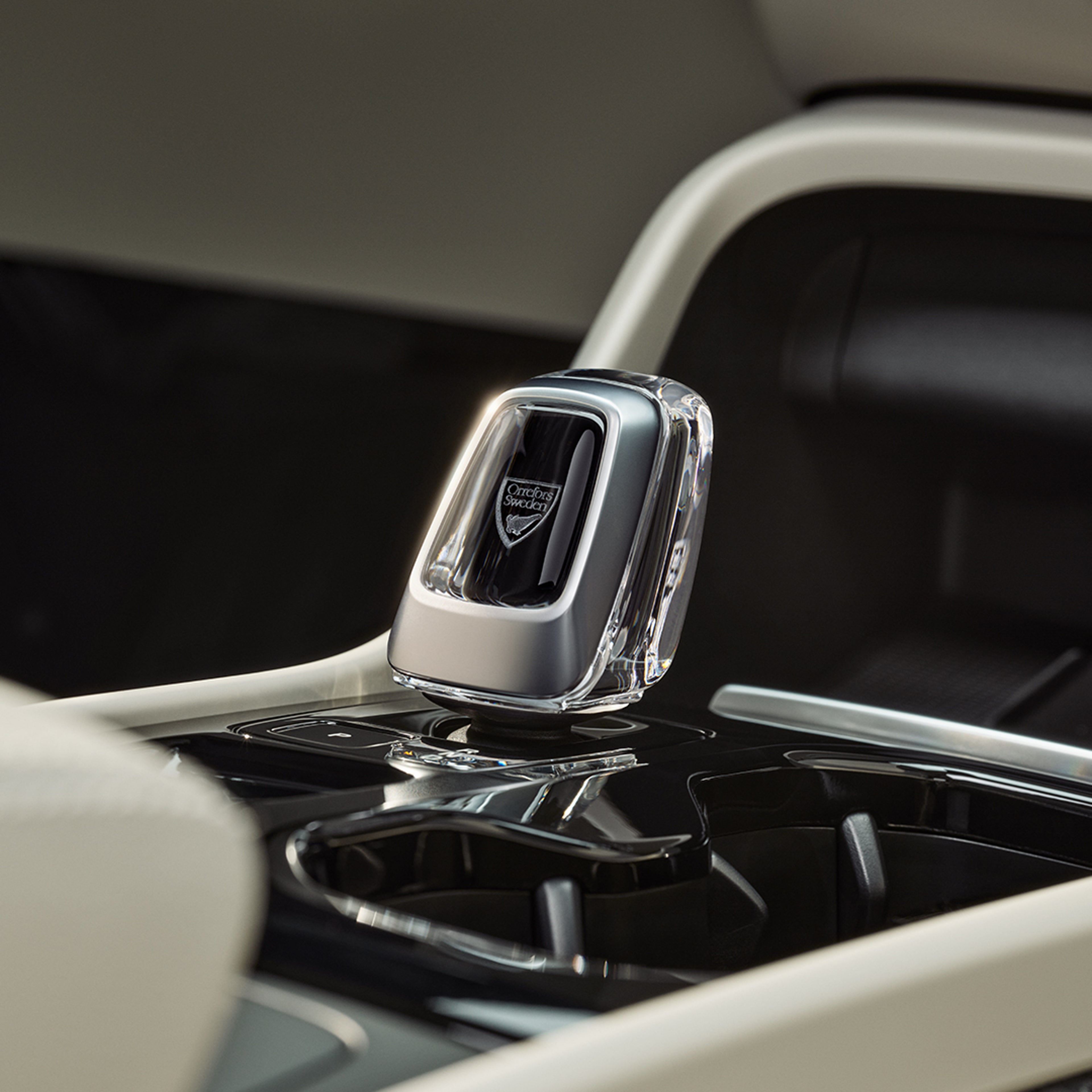 Detalle de la palanca de cambios de cristal en la consola central negra brillante del Volvo XC40 semihíbrido.