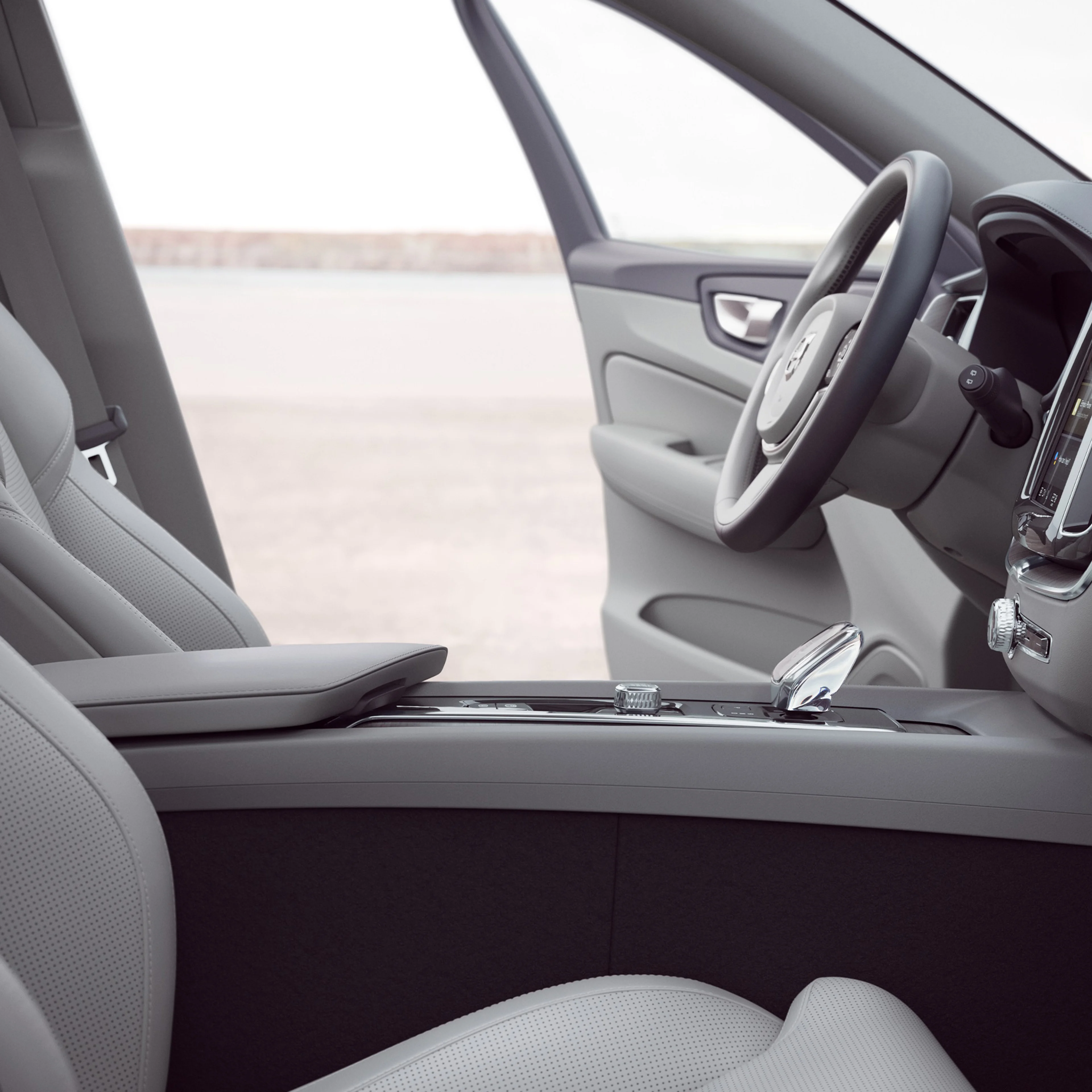Innanrými Volvo XC40 að framan, hurð ökumanns er opin.