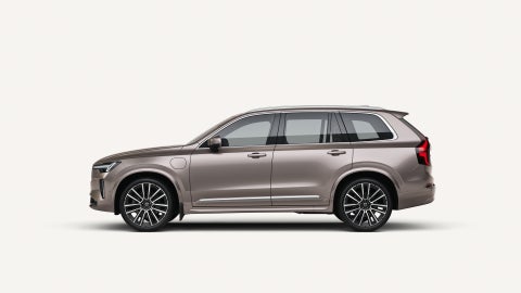 Zijaanzicht van de Volvo XC90 Plug-in hybrid in een witte studio-omgeving.