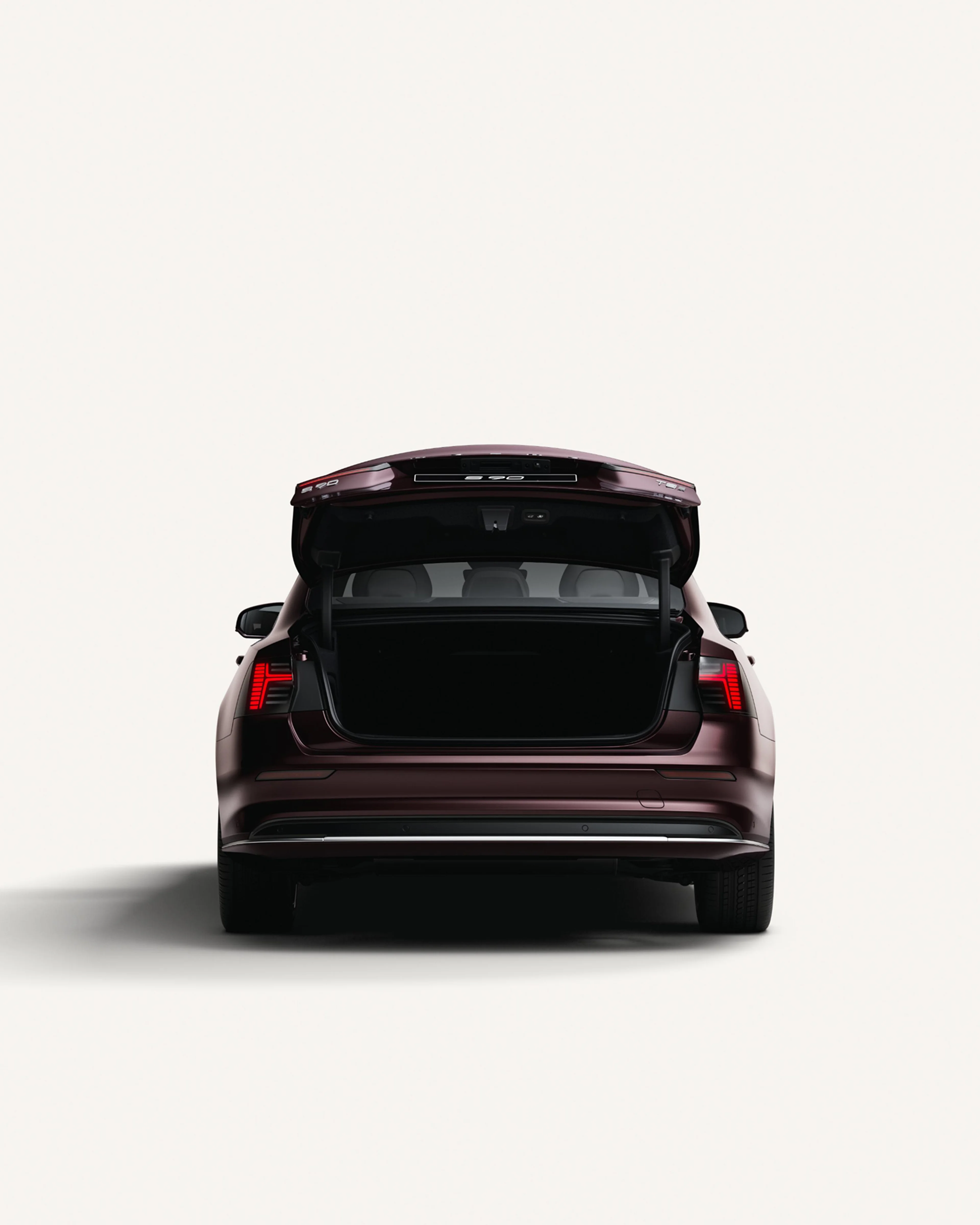 Rear view of the Volvo S90 with the trunk open in a white studio environment.