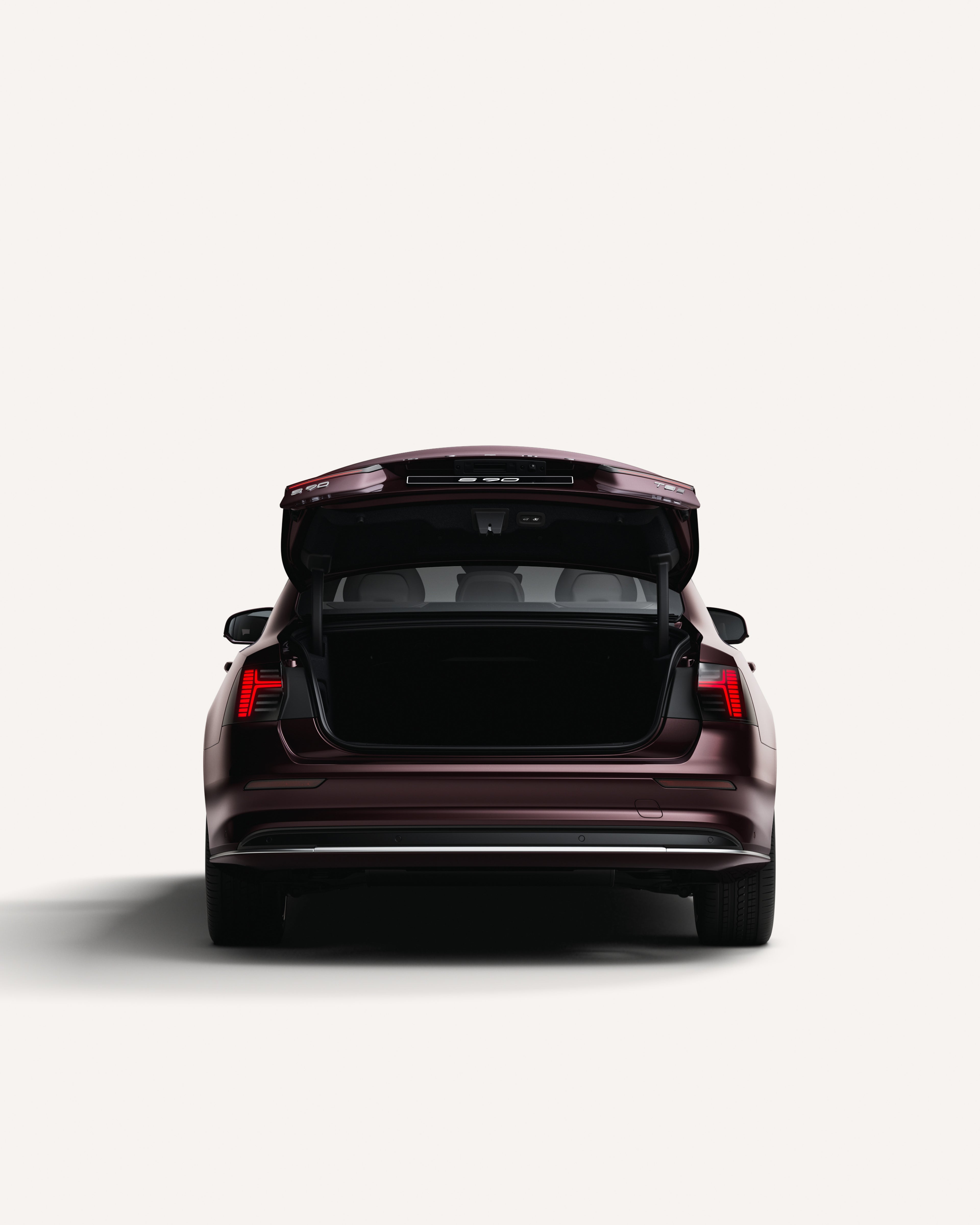 Rear view of the Volvo S90 with the trunk open in a white studio environment.