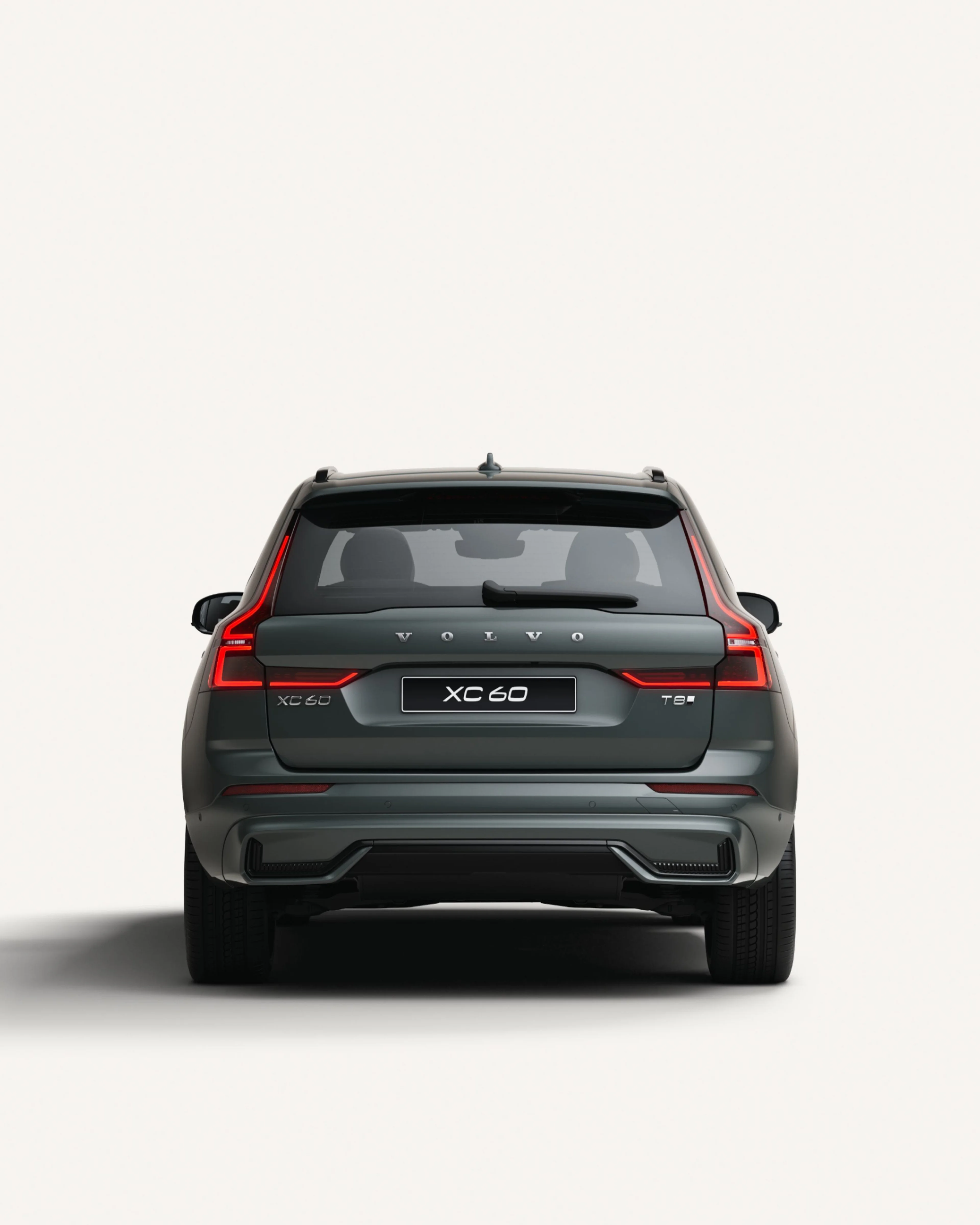 Rear view of the Volvo XC60 midsize plug-in hybrid SUV in a white studio environment.