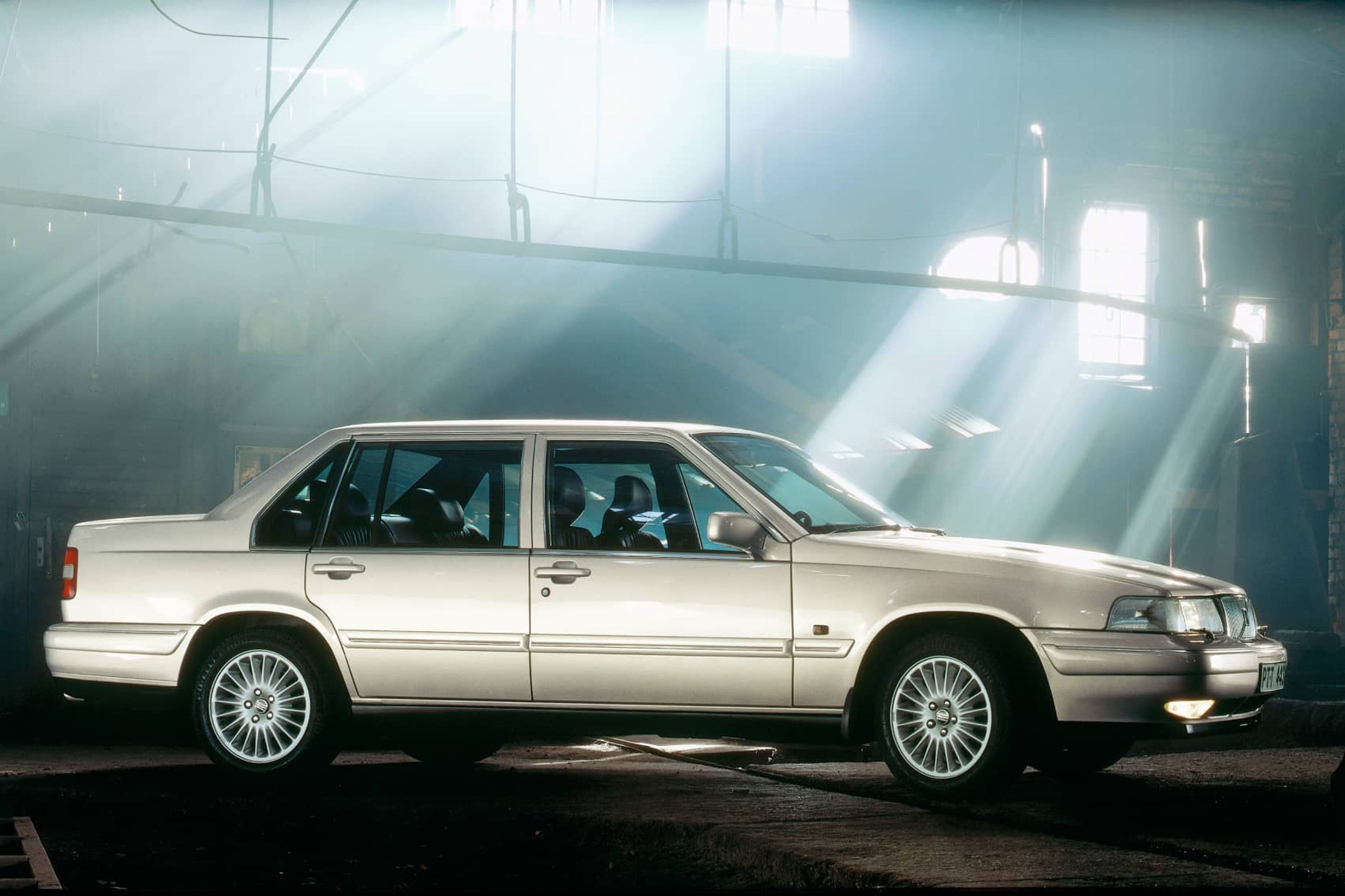 Un sedán Volvo 960 fotografiado desde un lateral dentro de un almacén.