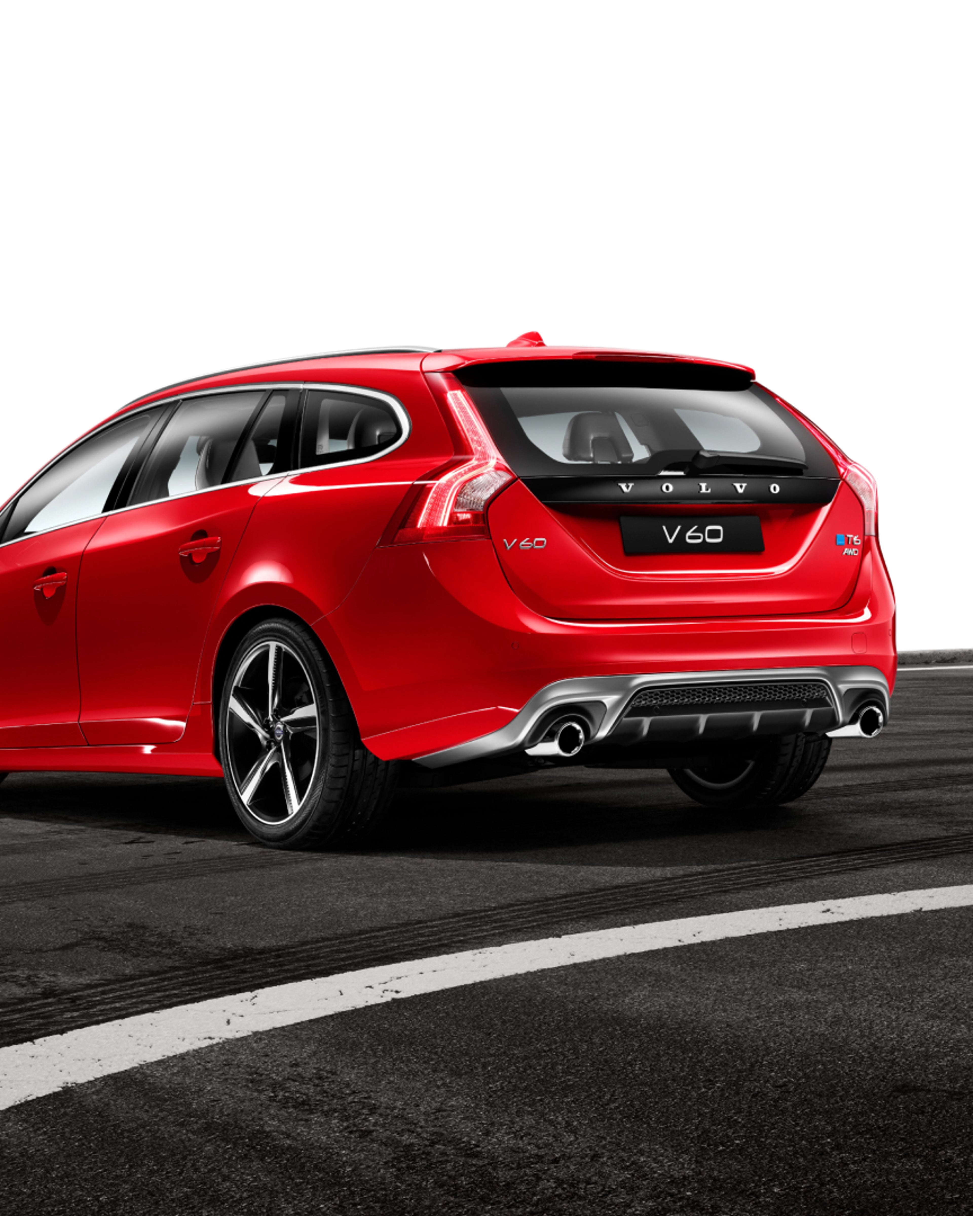 Volvo V60 avec un câble de recharge connecté, garé à côté d’une maison.