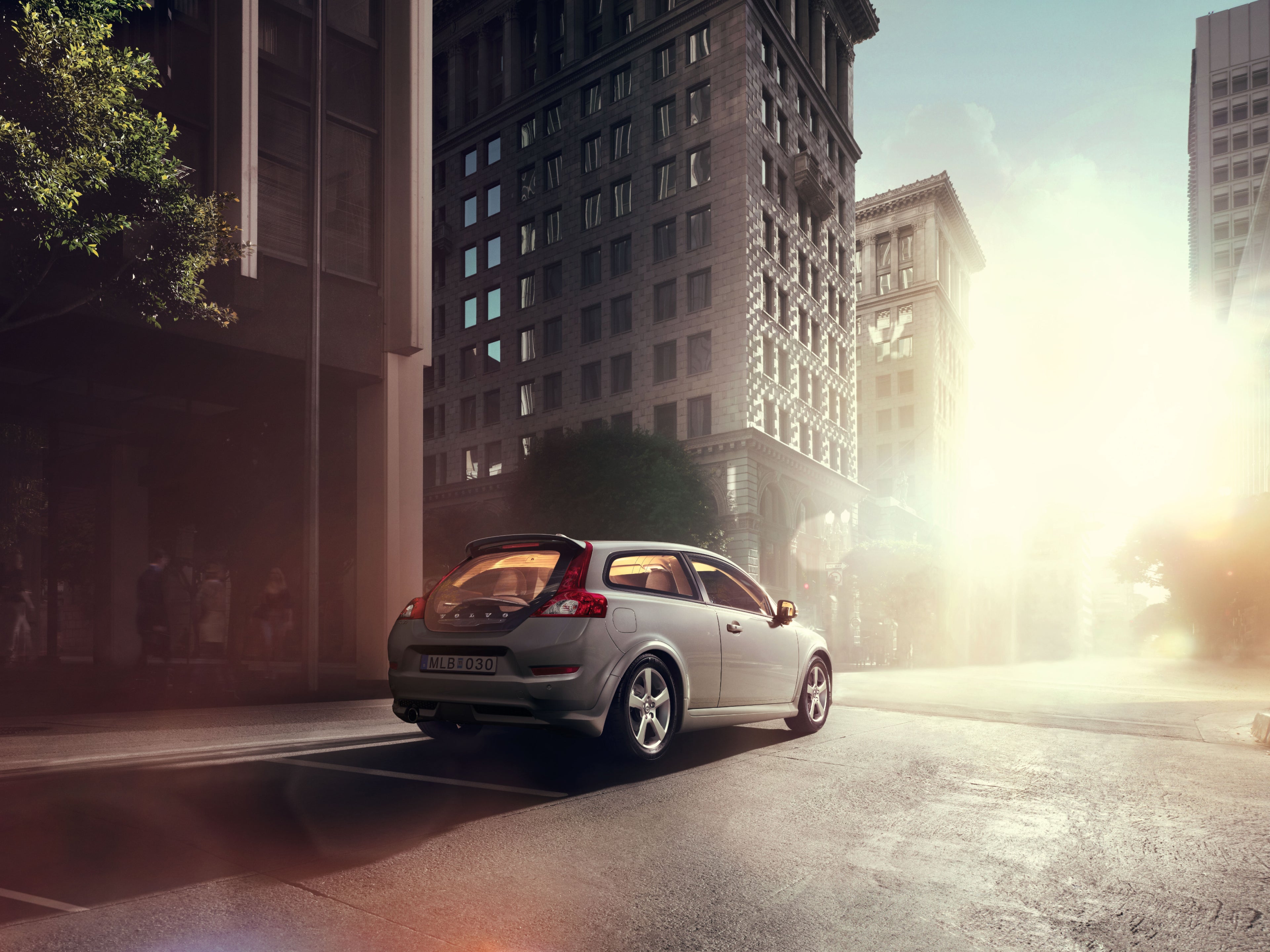 A Volvo C30 parked in front of an old building.