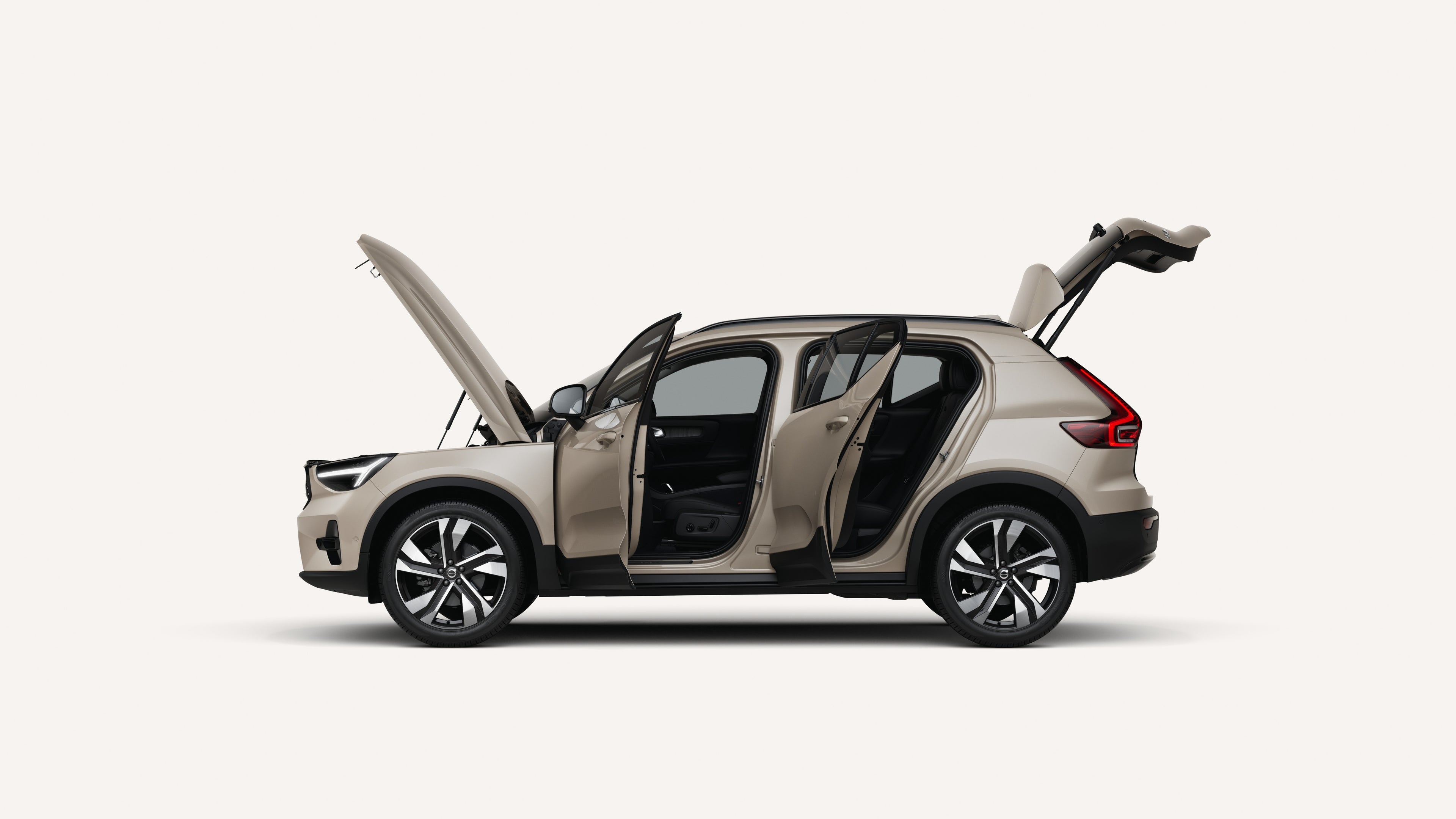 Side view of the Volvo XC40 with open hood, doors, and trunk in a white studio environment.