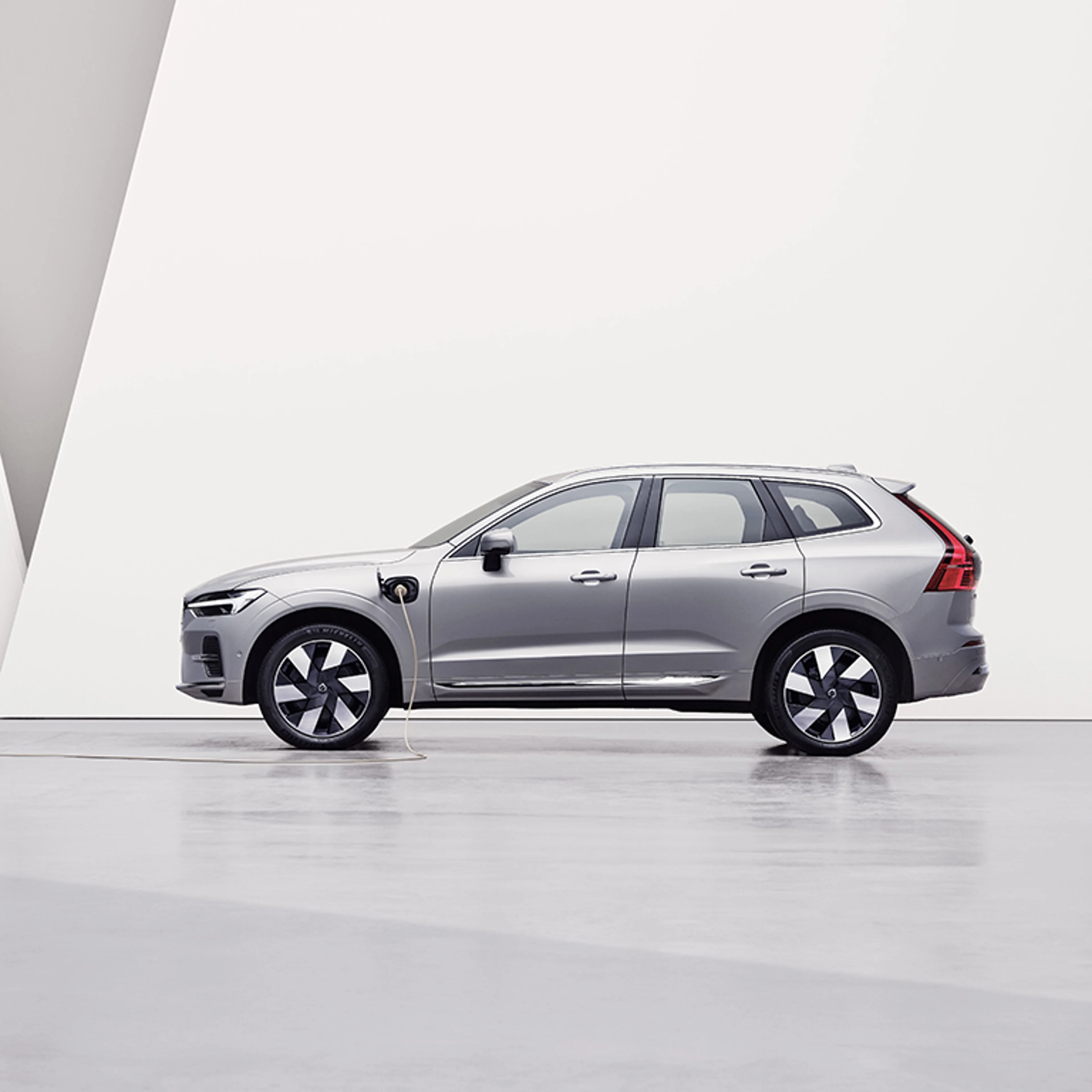 在紫色背景下充電的 Volvo XC60 雙能電動車。