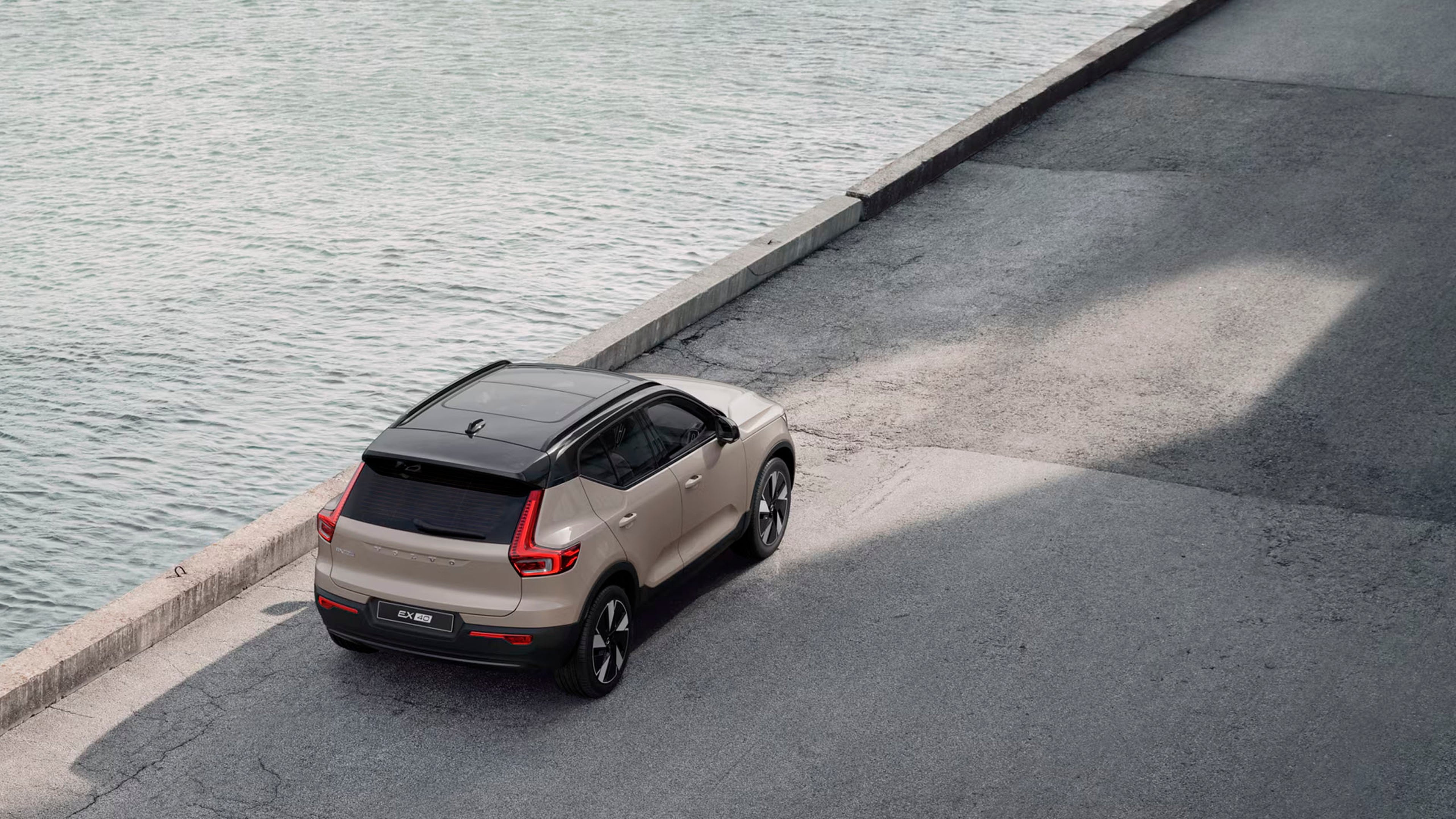 Volvo EX40 eléctrico vista aérea con techo solar en color Sand Dust