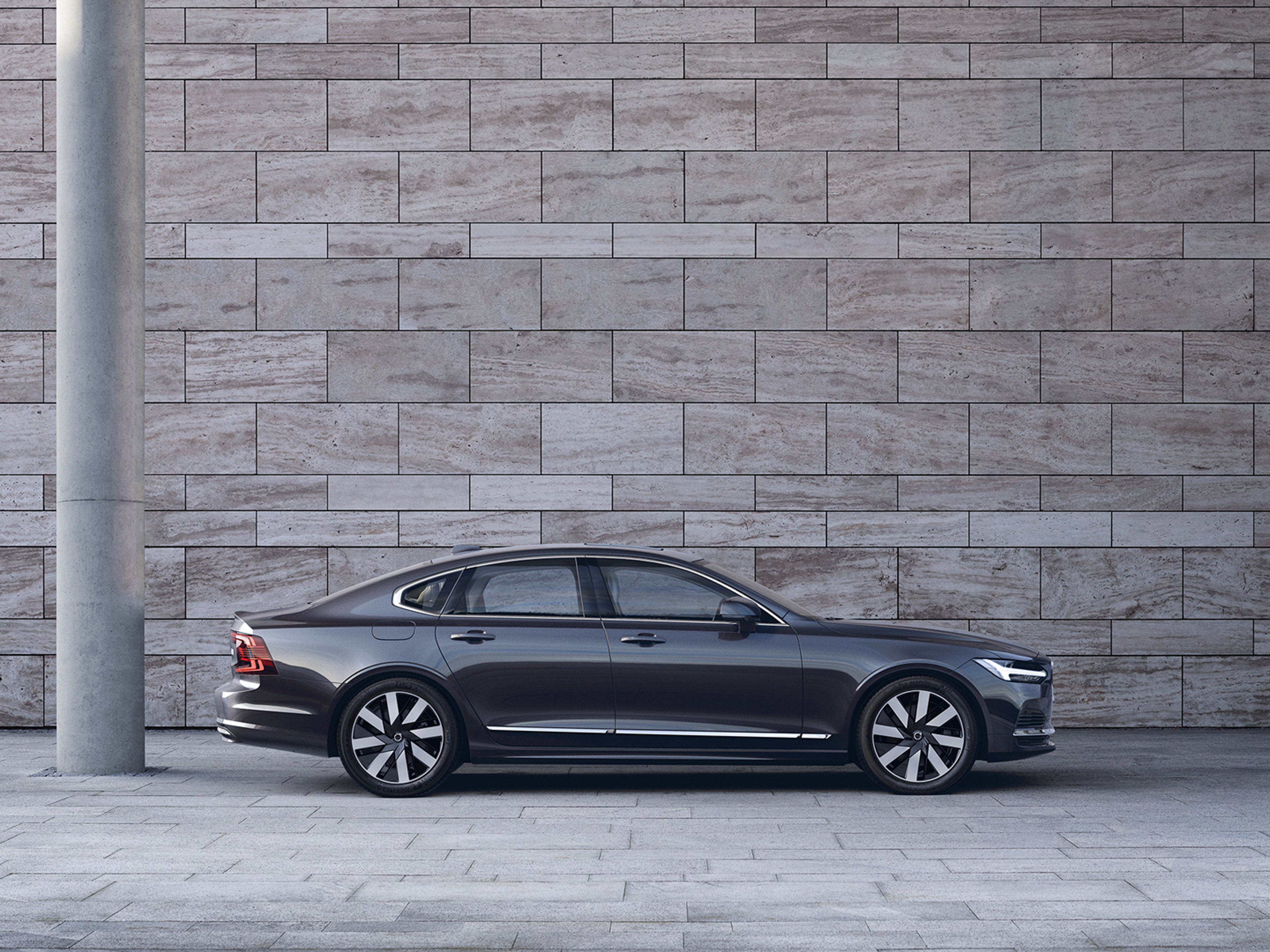 En Volvo S90 Recharge är parkerad framför en trappa.