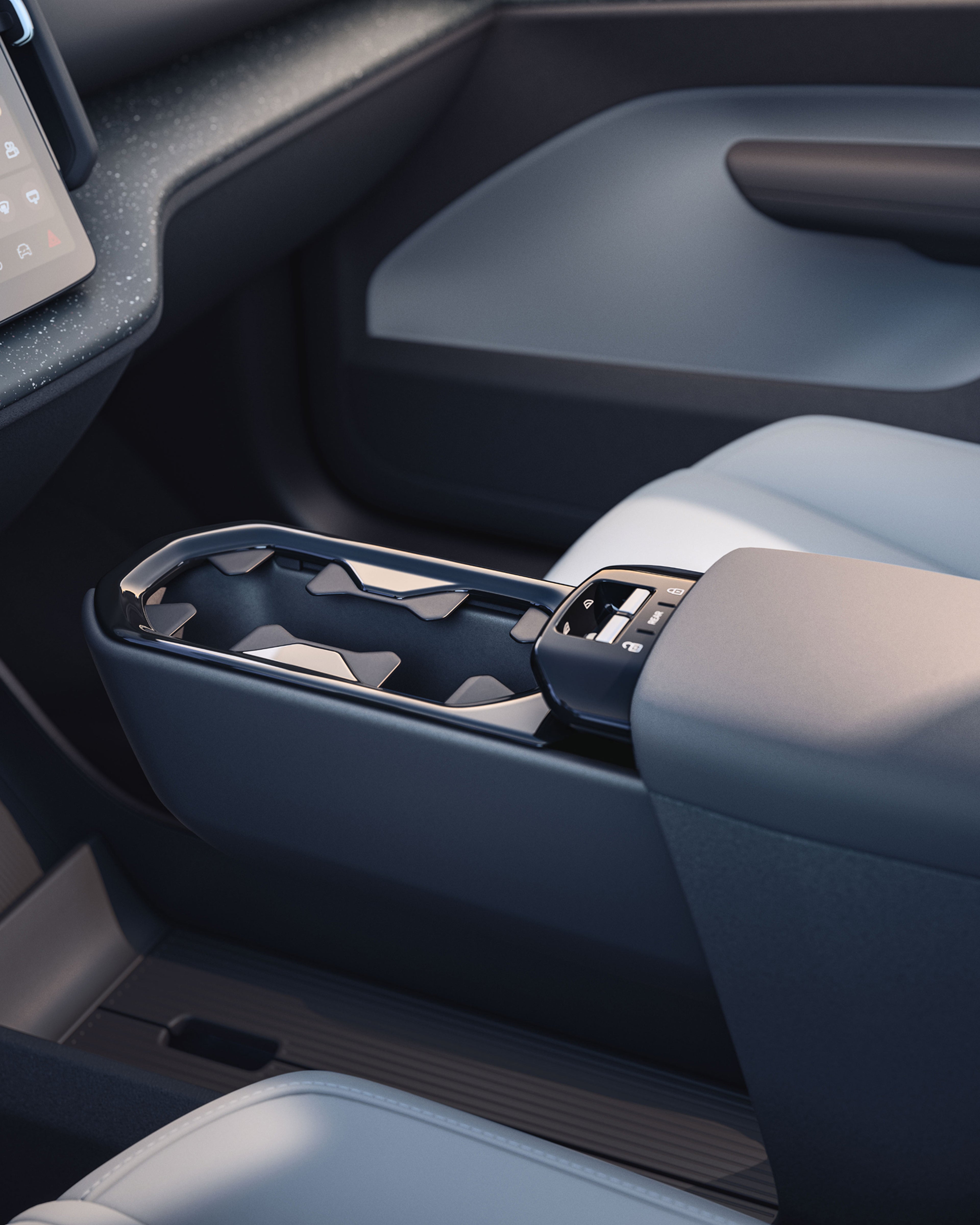 Primo piano della console centrale di Volvo EX30, che evidenzia il vano portaoggetti smart e il pad di ricarica.