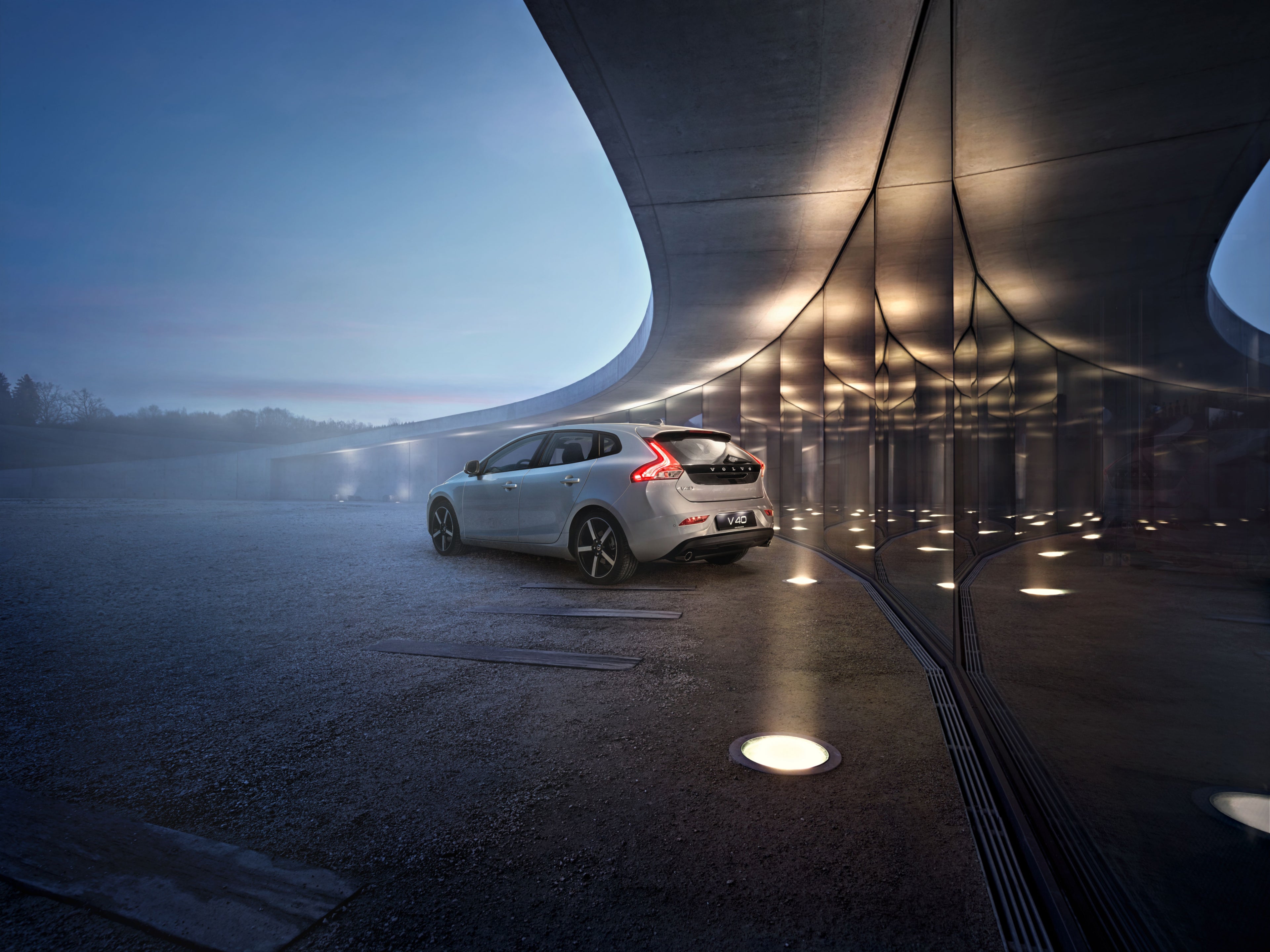 Immagine della parte posteriore di una Volvo V40 parcheggiata davanti a un edificio moderno.