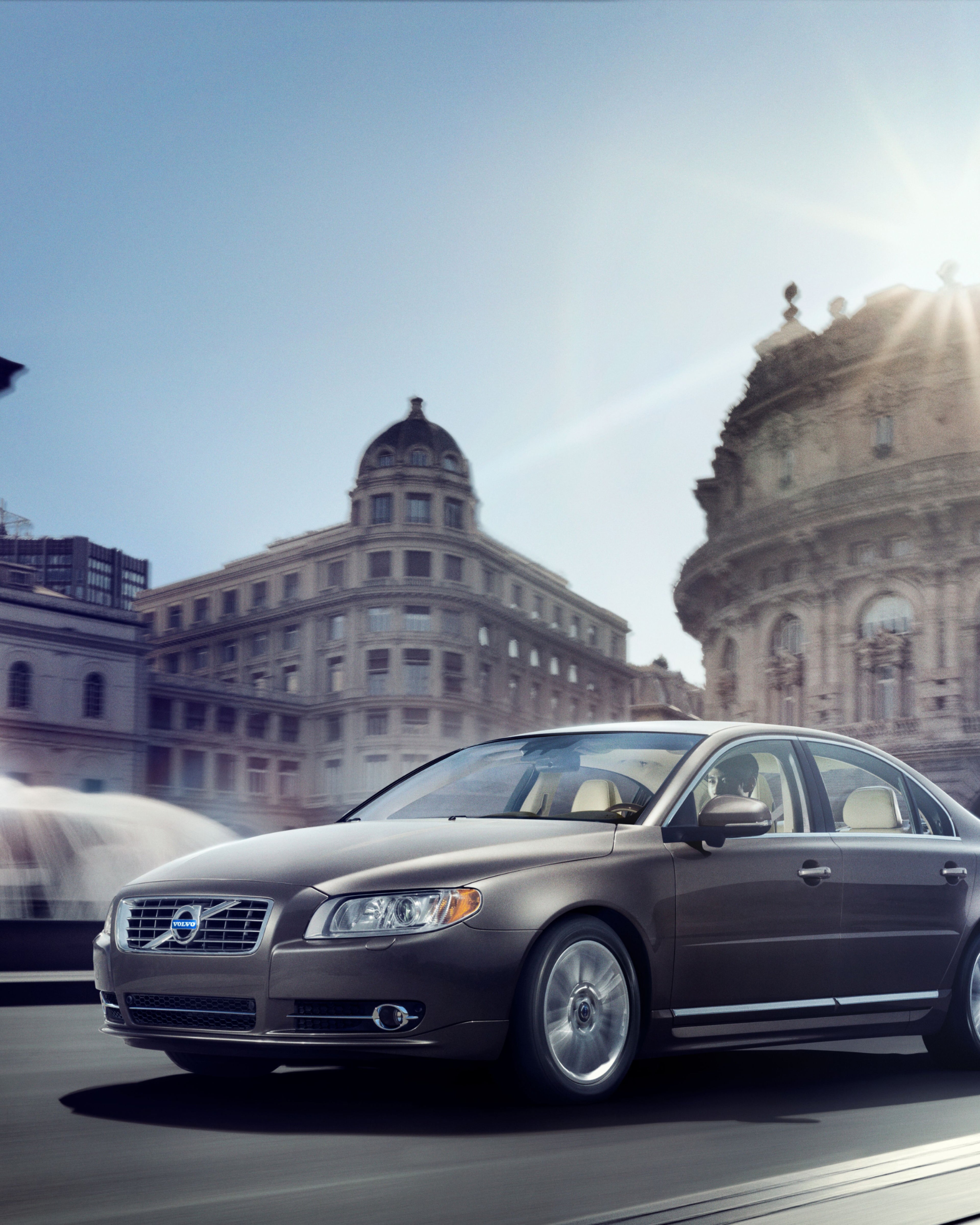Photo d’une Volvo S80 passant devant un bâtiment classique.