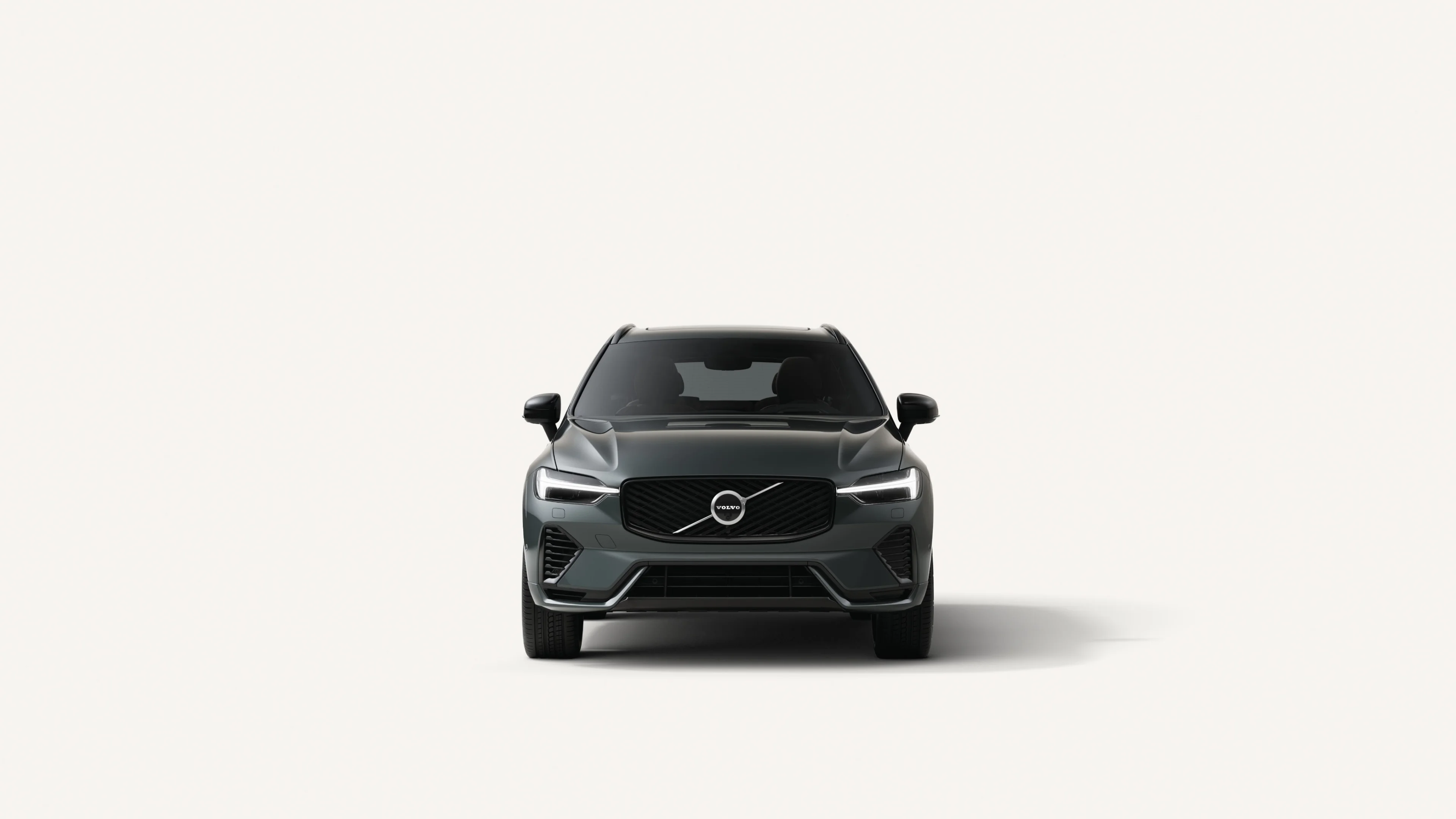Widok z przodu średniej wielkości SUV-a Volvo XC60 o napędzie hybrydowym typu Plug-in w białym studiu.