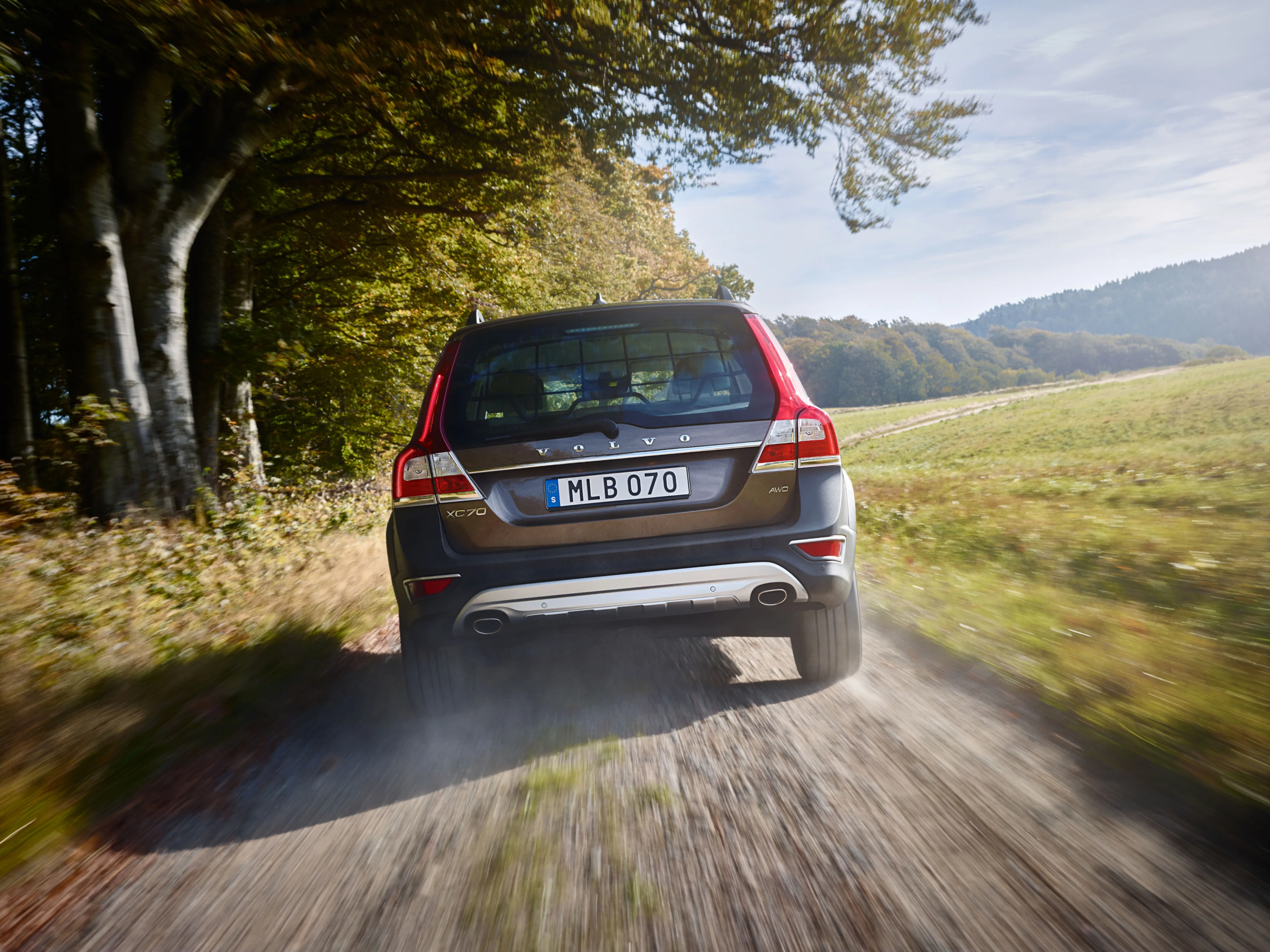A picture showing the rear of a Volvo XC70 driving on a dusty road.